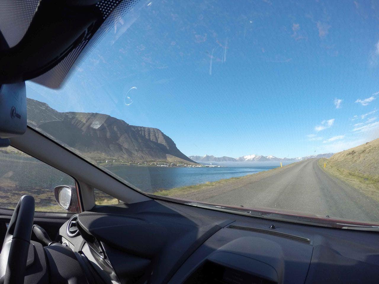 Looking at a mountain through a car window on a sunny day