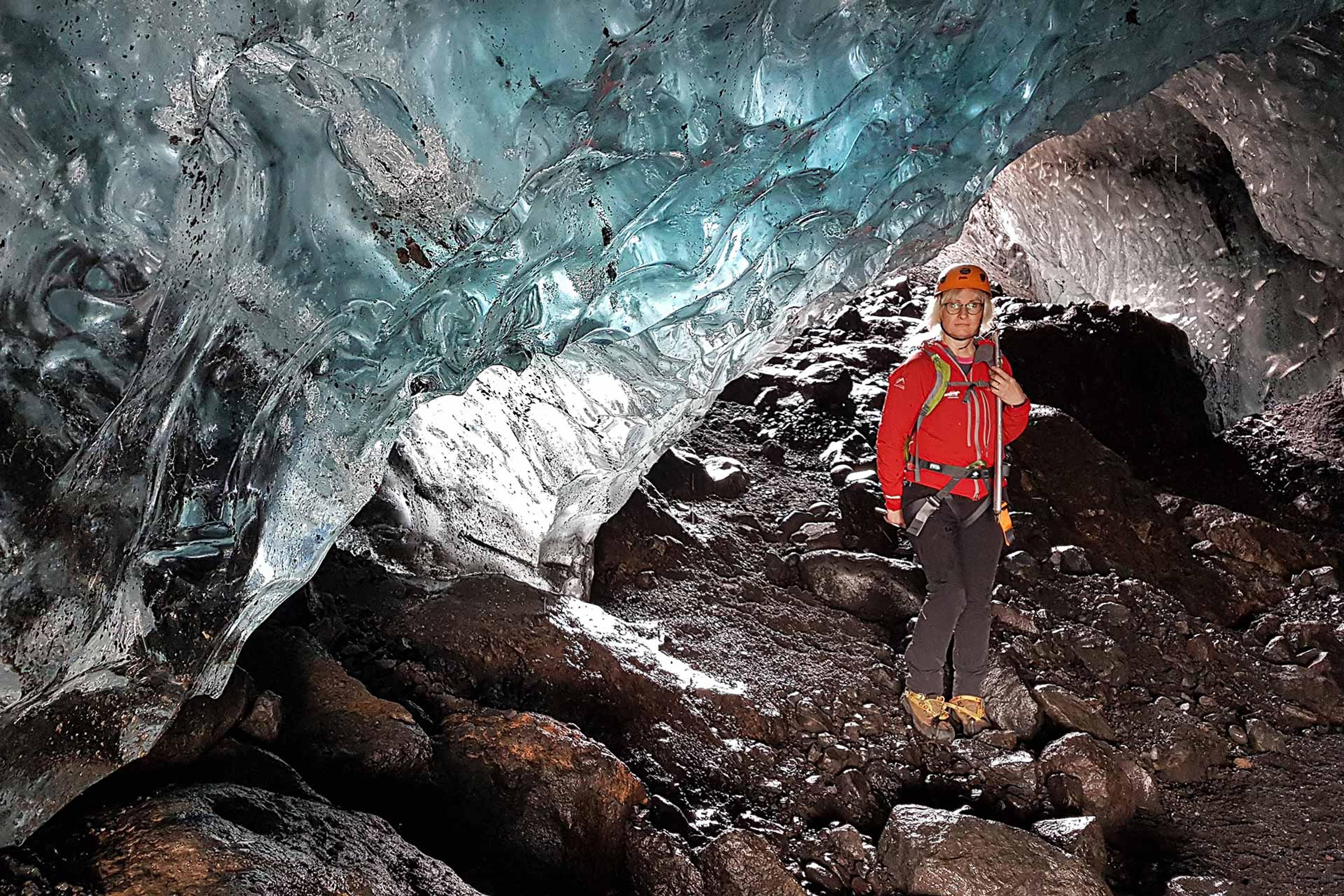 A woman in red jacked inside an ice cave