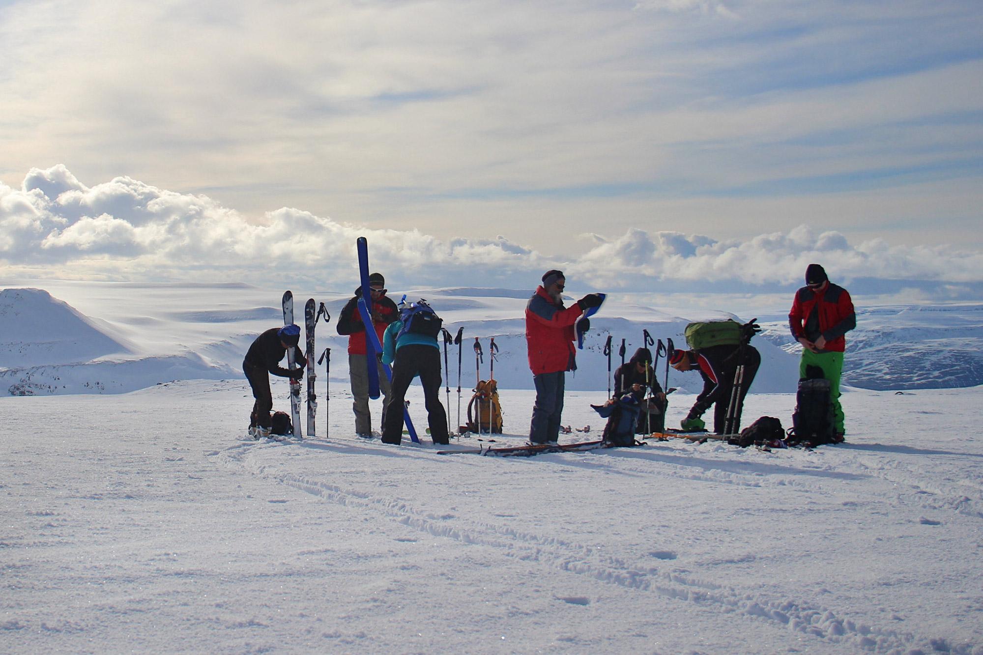 A group of explorers taking a quick break on a snowy mountain in the North of Iceland