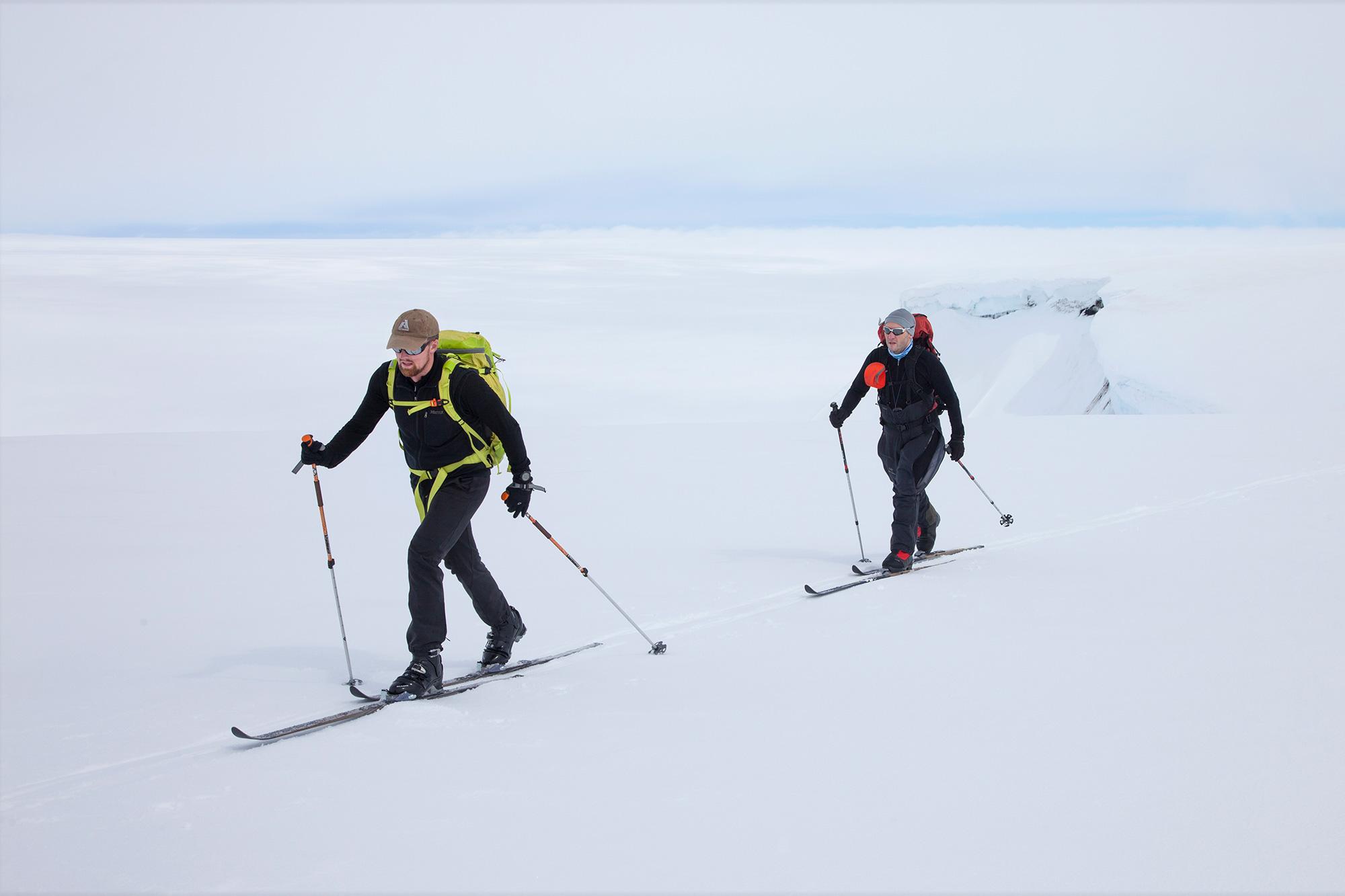 Two men skiing along the hjuge and active Grímsvötn volcanic crater in the middle of Vatnajökull glacier