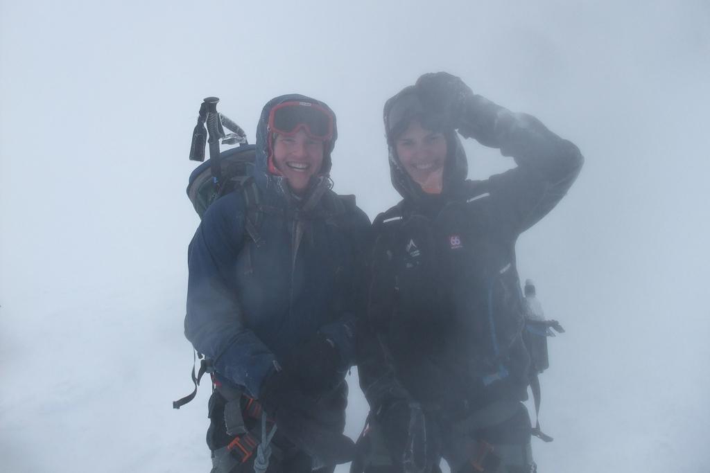 Hikers in rain gear on a foggy trail, experiencing challenging weather while hiking in Iceland.