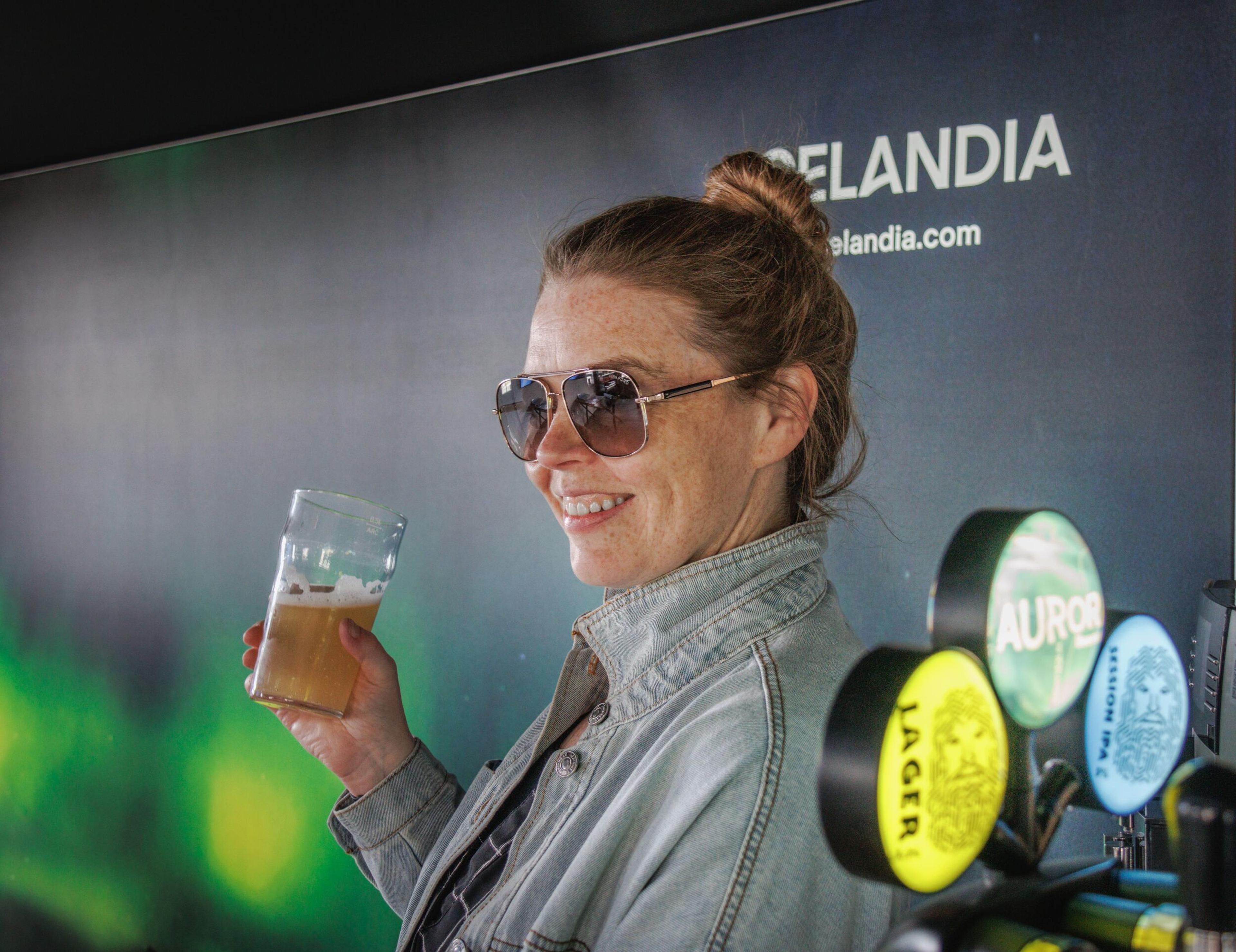 Woman enjoying a beer and smiling.