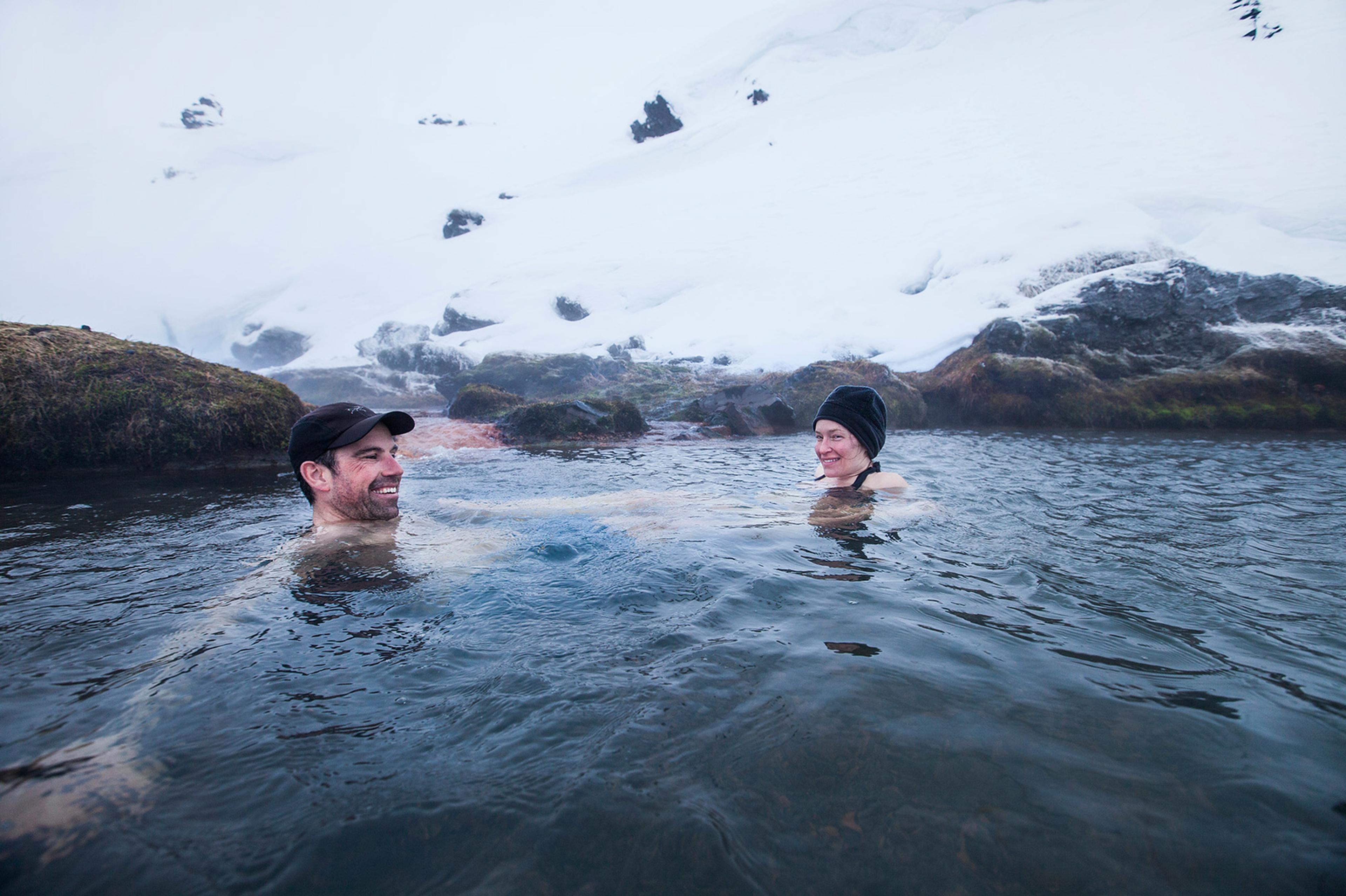 People enjoying a hot bath in a geothermal hot pool in Landmannlaugar