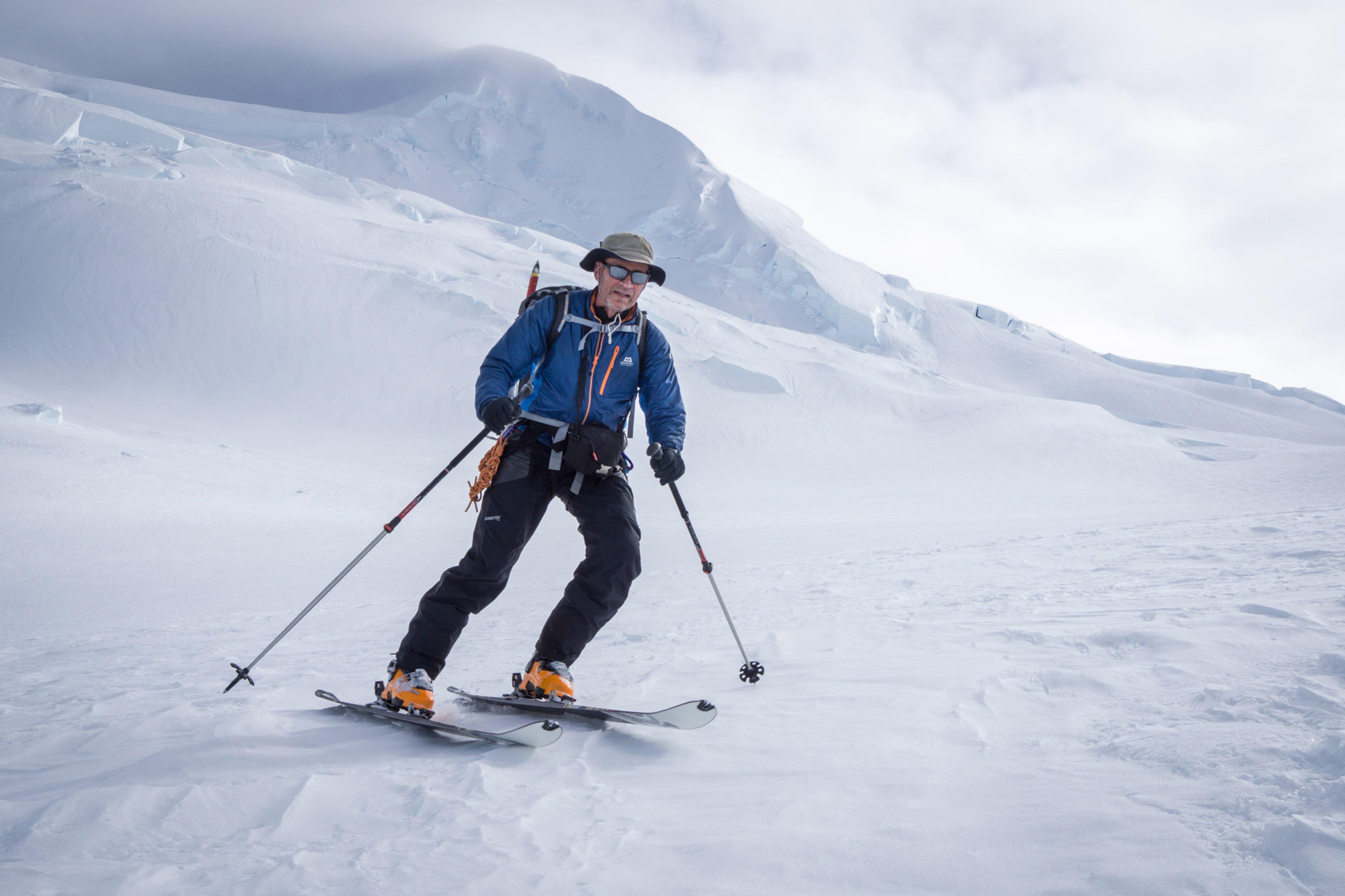 a man skiing down from one of the high peaks