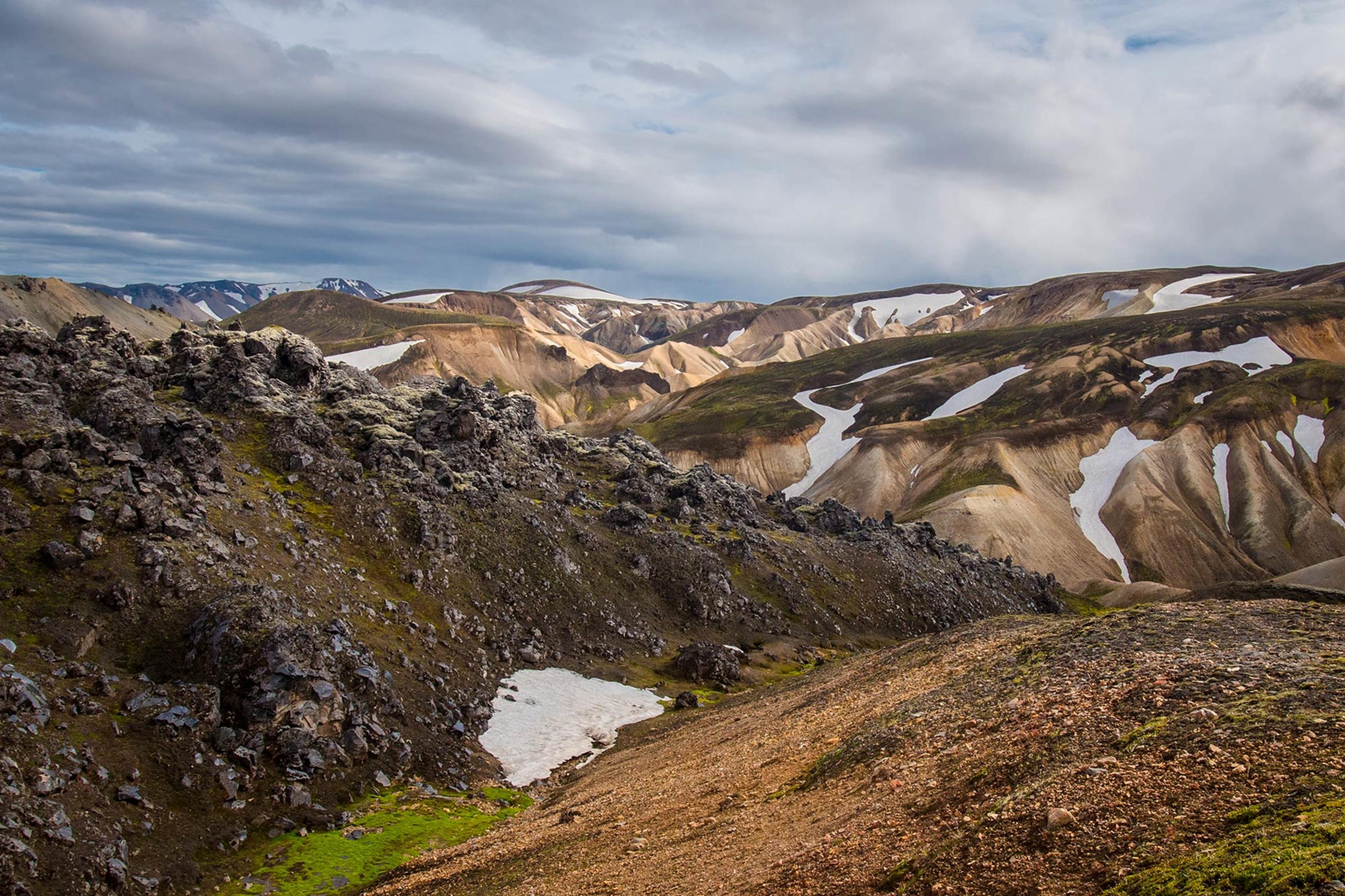 Red and grassy mountains with some snow on the famous Laugavegur trail in Iceland