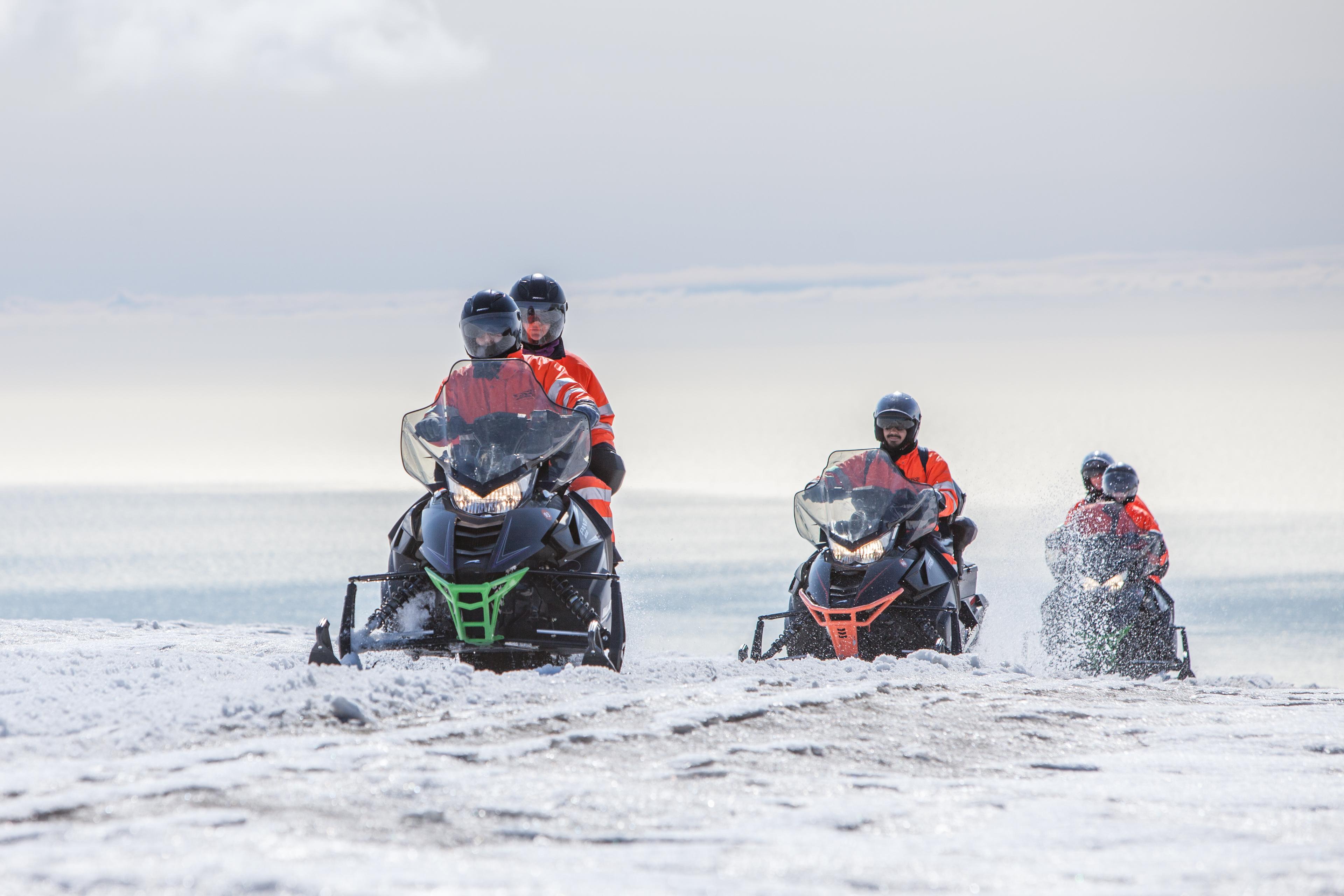 Riders of snowmobiles having fun on a great sunny day