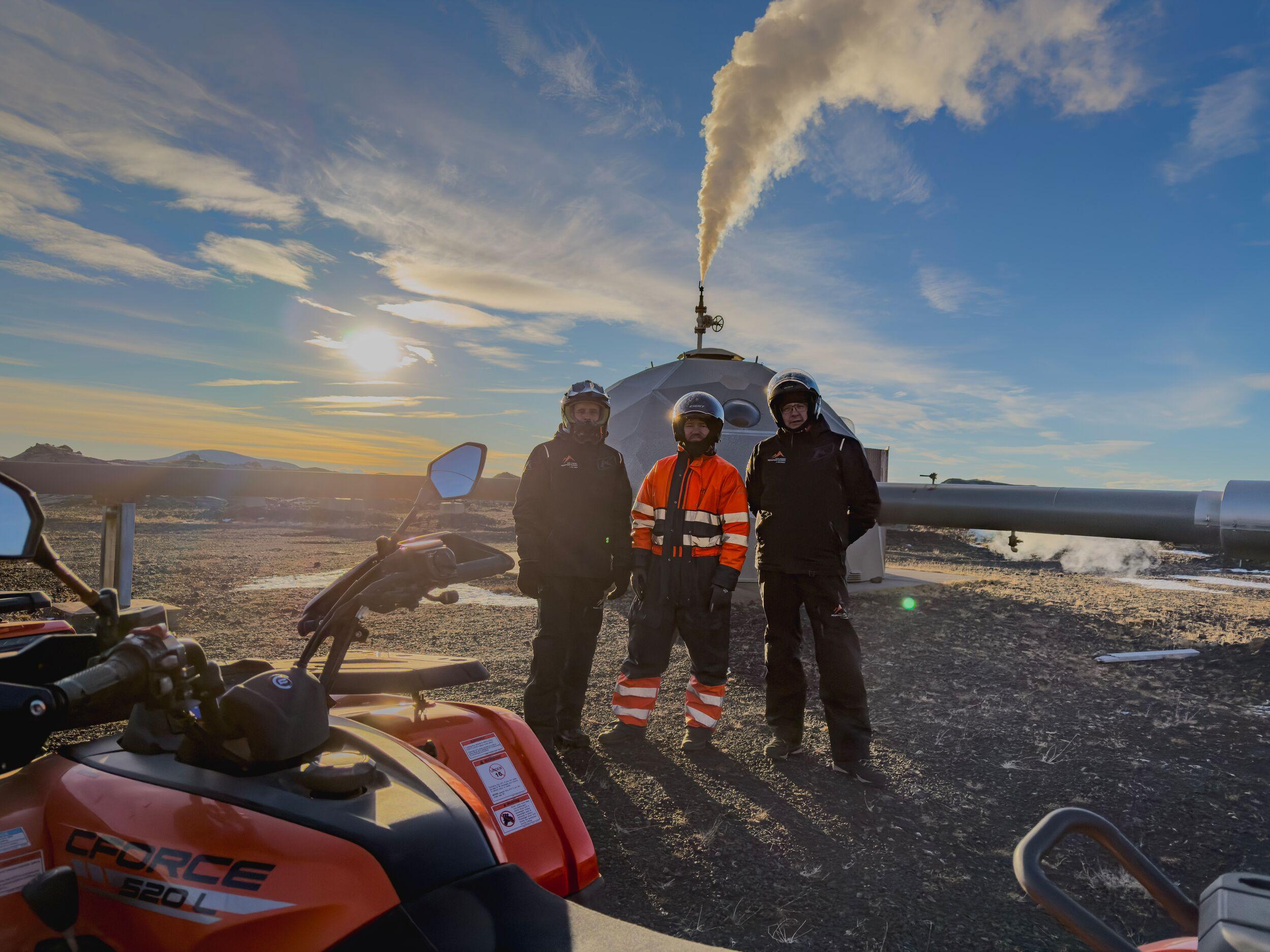 A rounded building with steam coming from the roof, three people inside, and an ATV in front