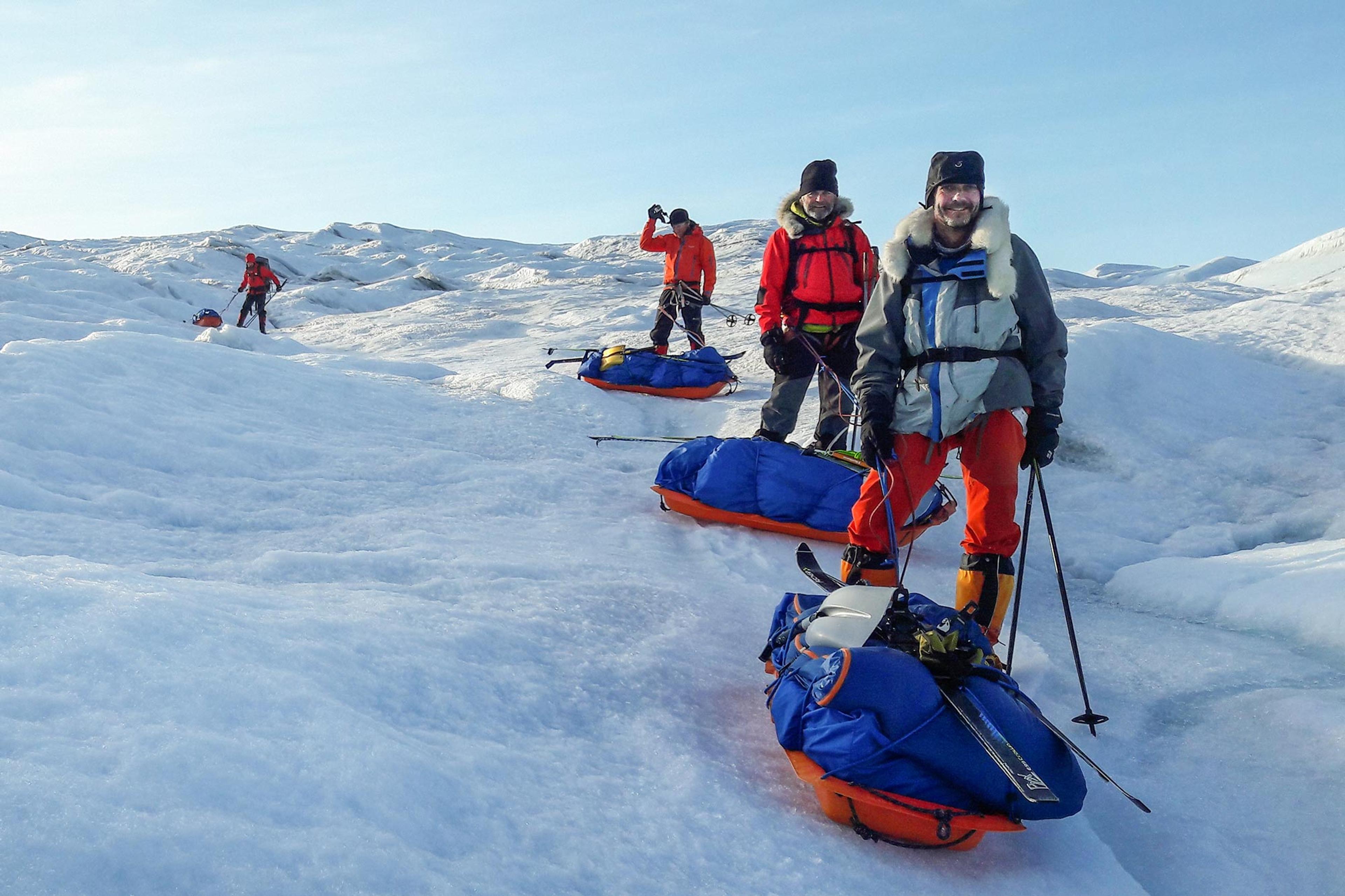 Four skiers navigating through an uneven ice field
