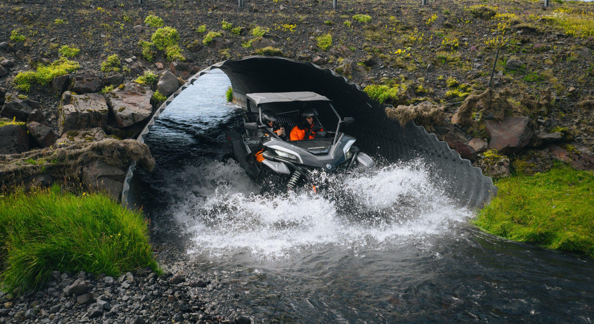 A buggy driving in a river under a road