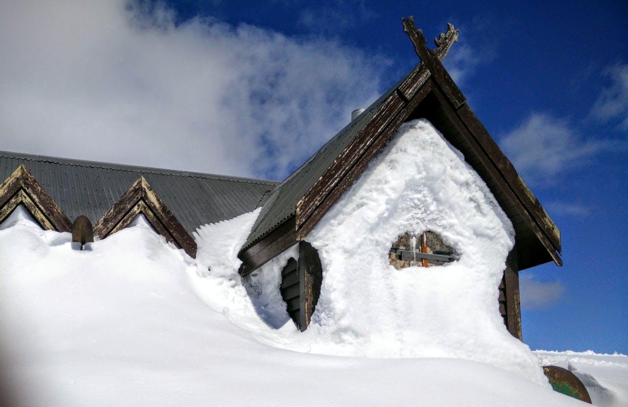 A mountain hut covered in snow