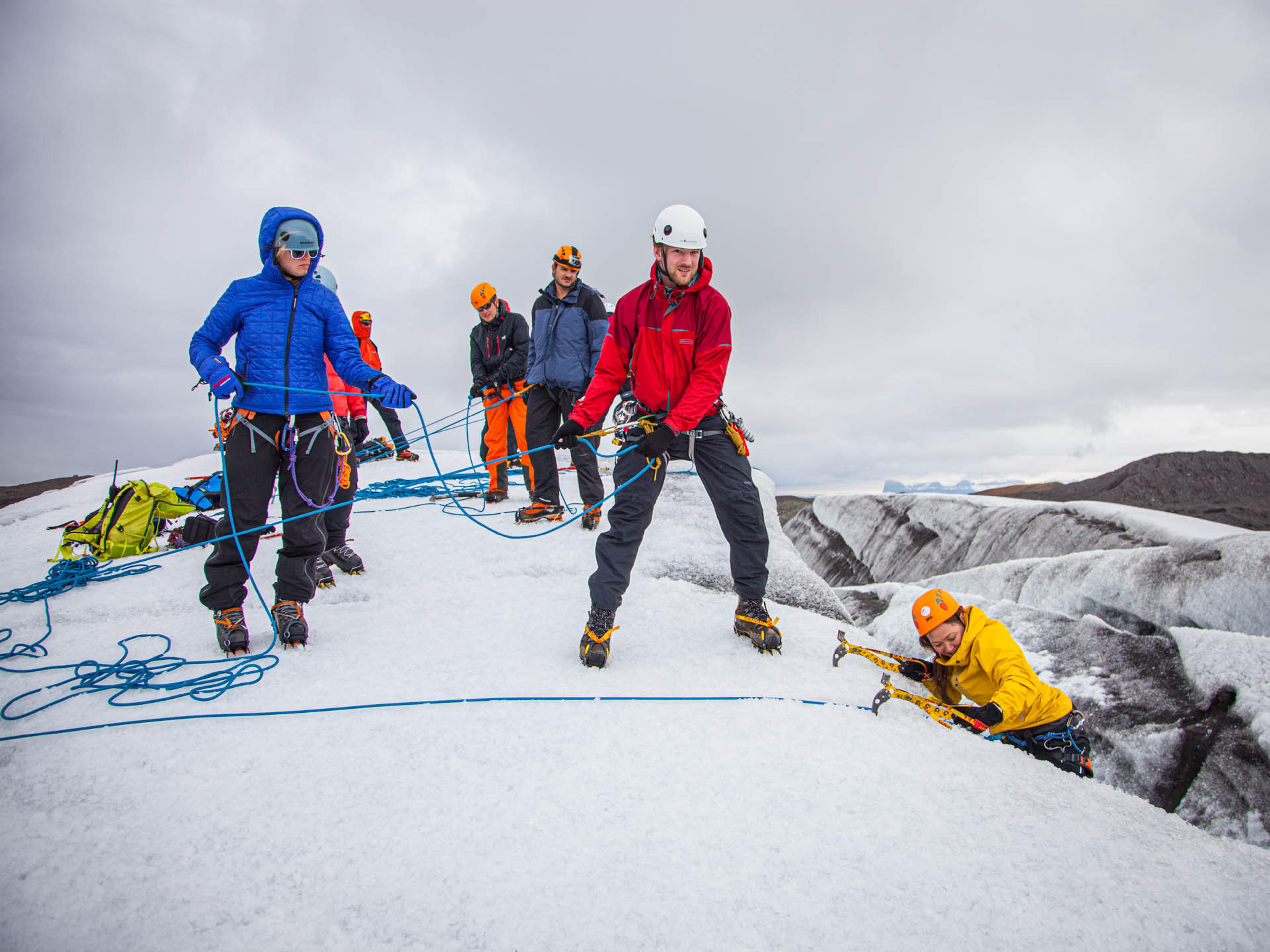 a group of people helping each other ice climb up a glacier