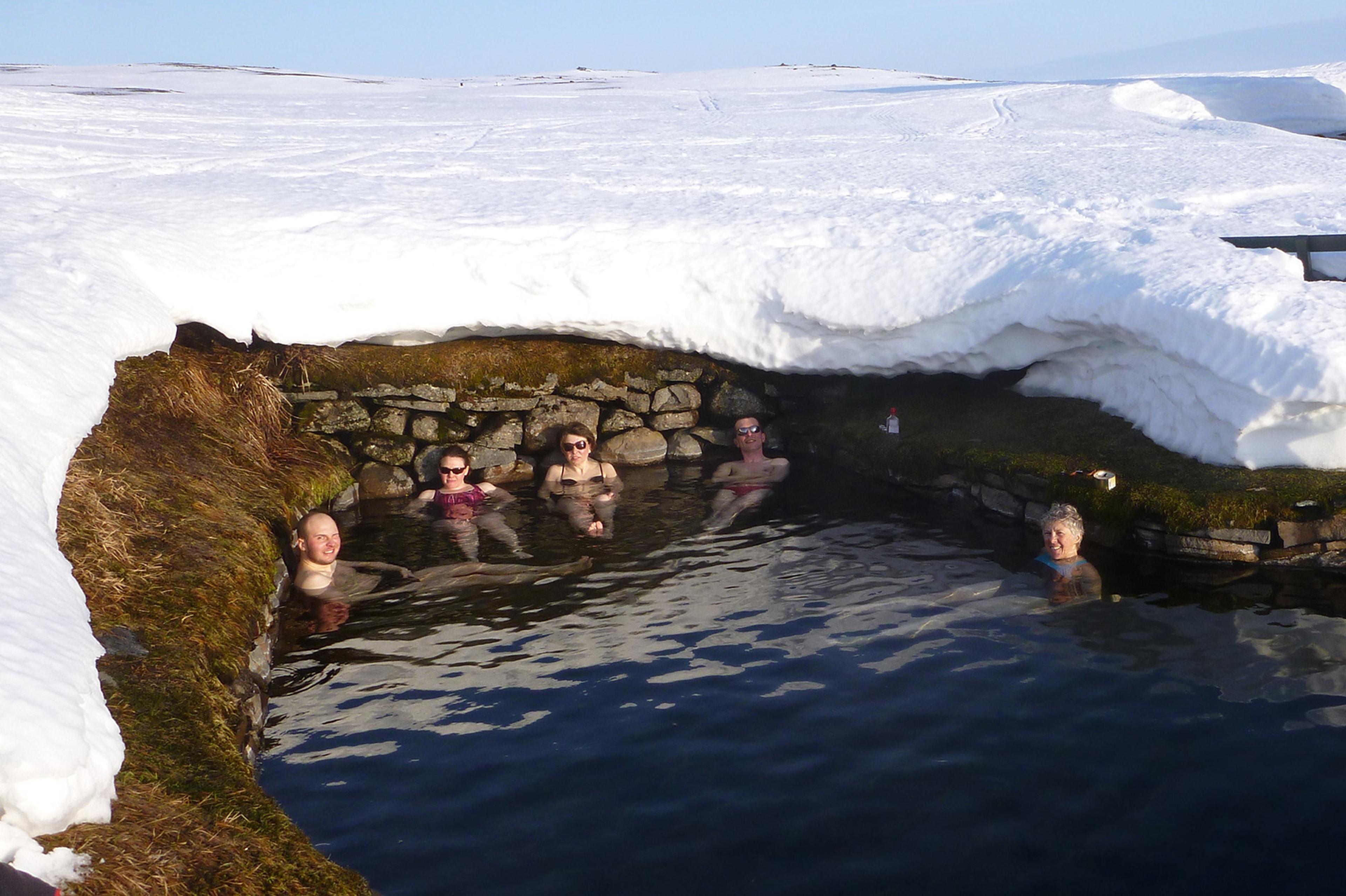 People enjoying a bath in a geothermal hot pool in the highlands