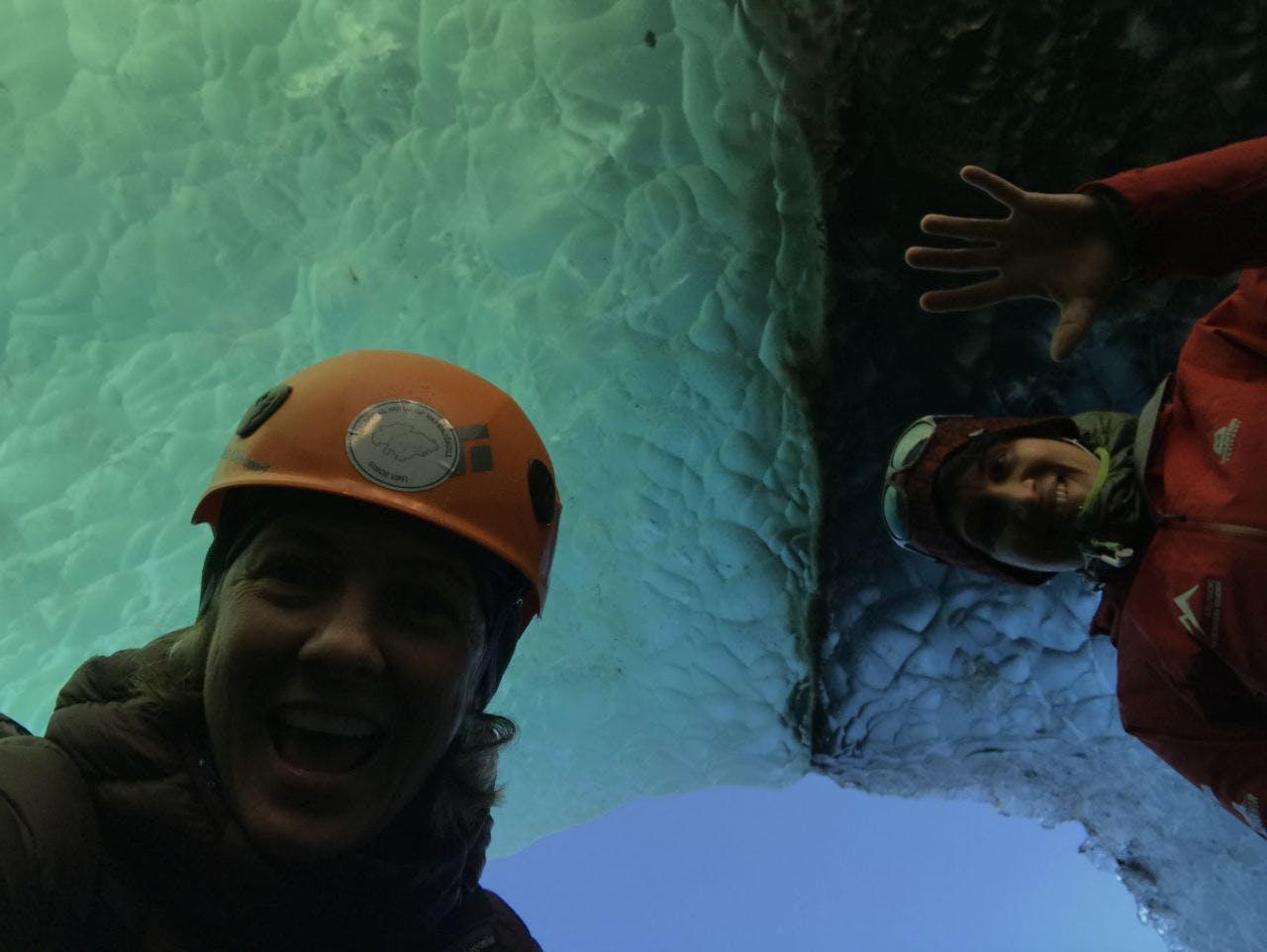 two smiling people in an ice cave