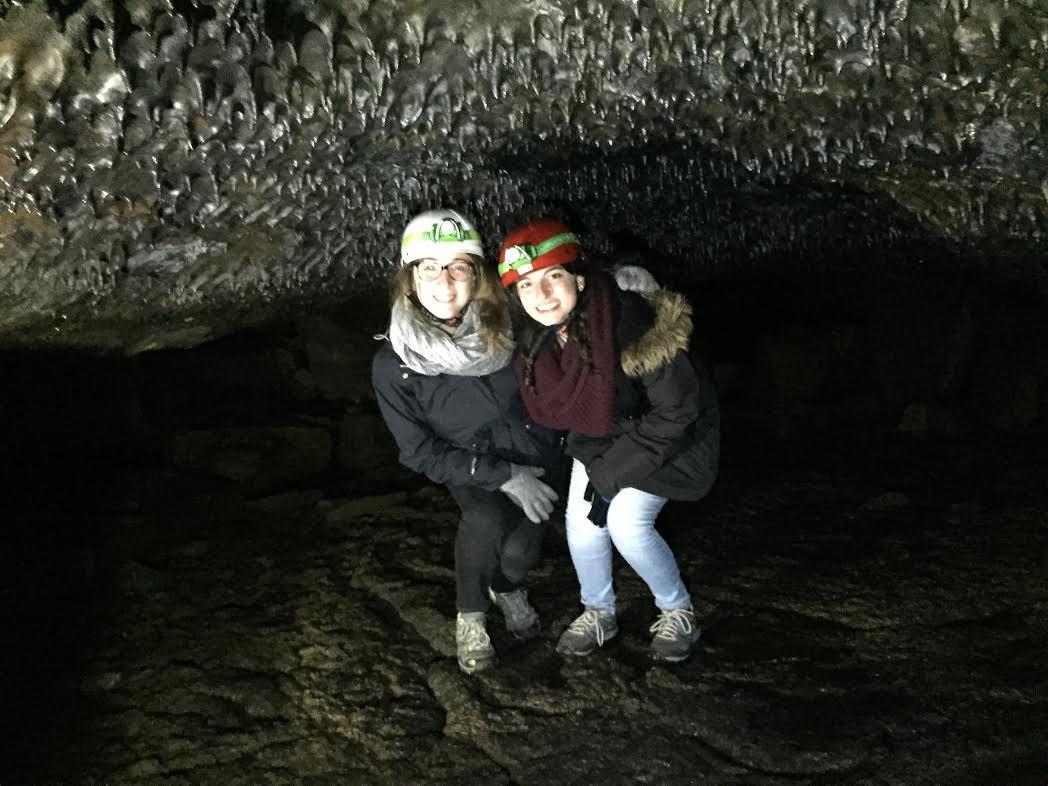 Sydney, Icelandic Mountain Guide's Adventurer of the Week, is inside of a lava cave with her another young woman.