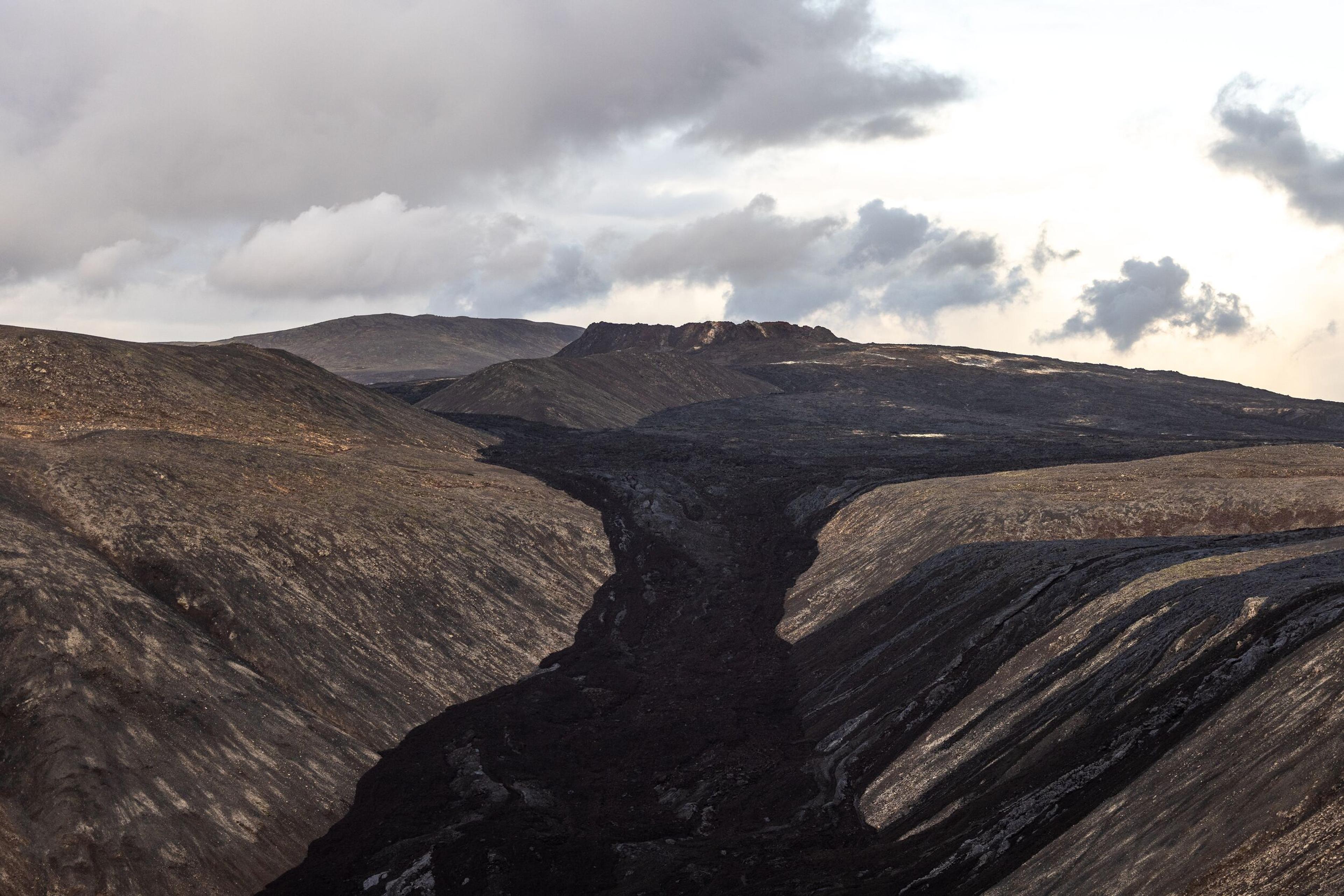 Black new lava which has flowed into a valley