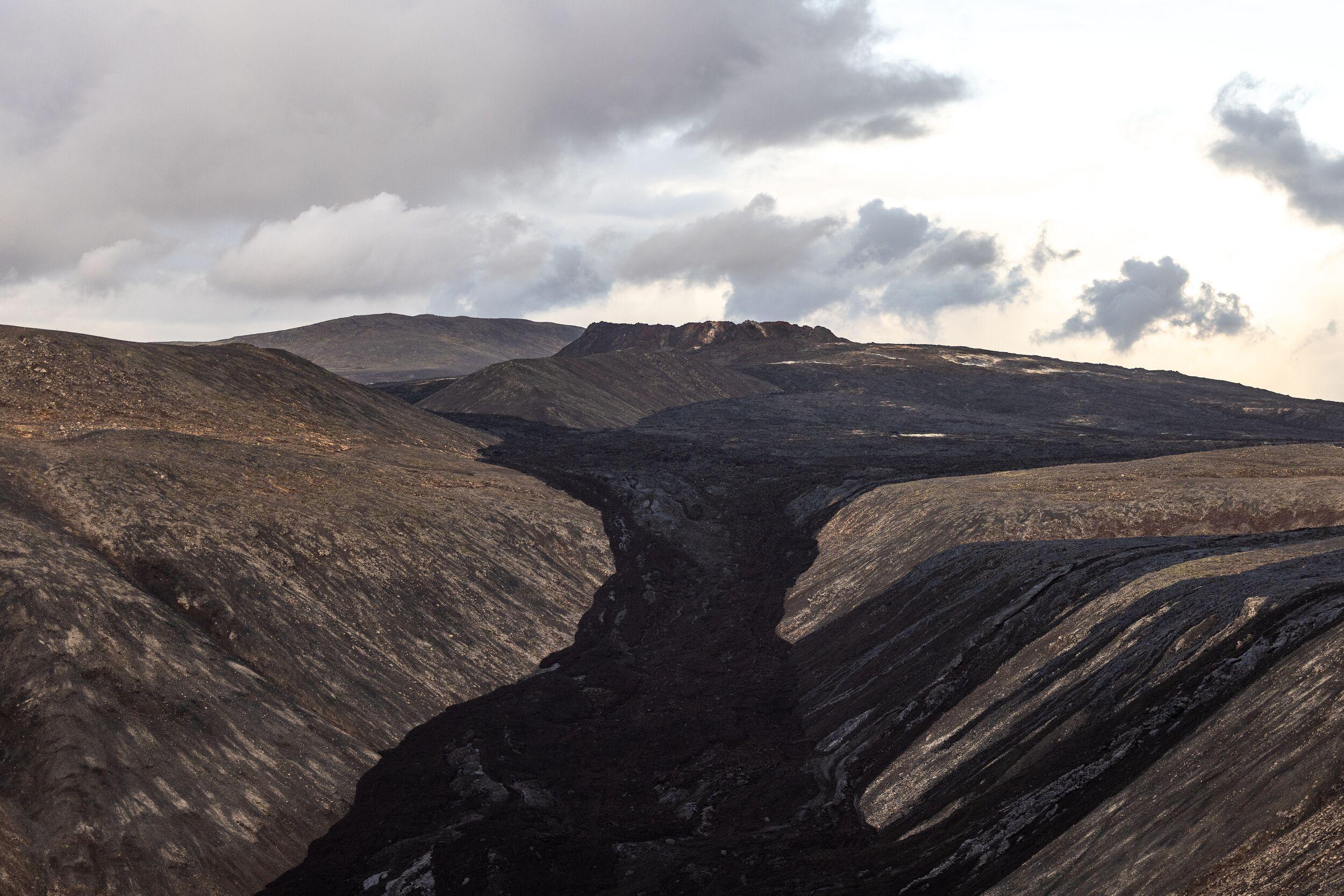 Black new lava which has flowed into a valley