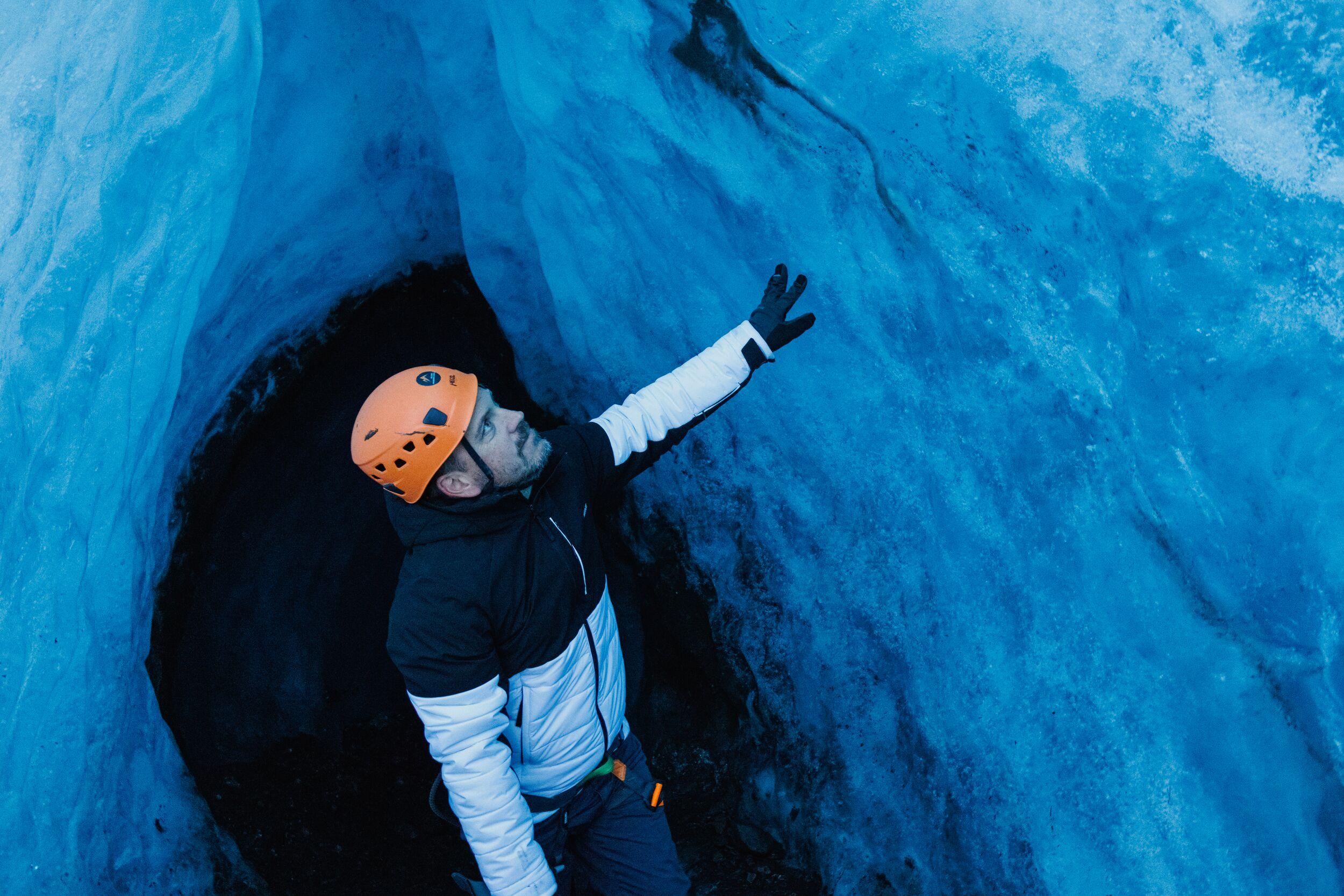 a man inside a blue ice cave on an outlet glacier of Vatnajökull in Iceland