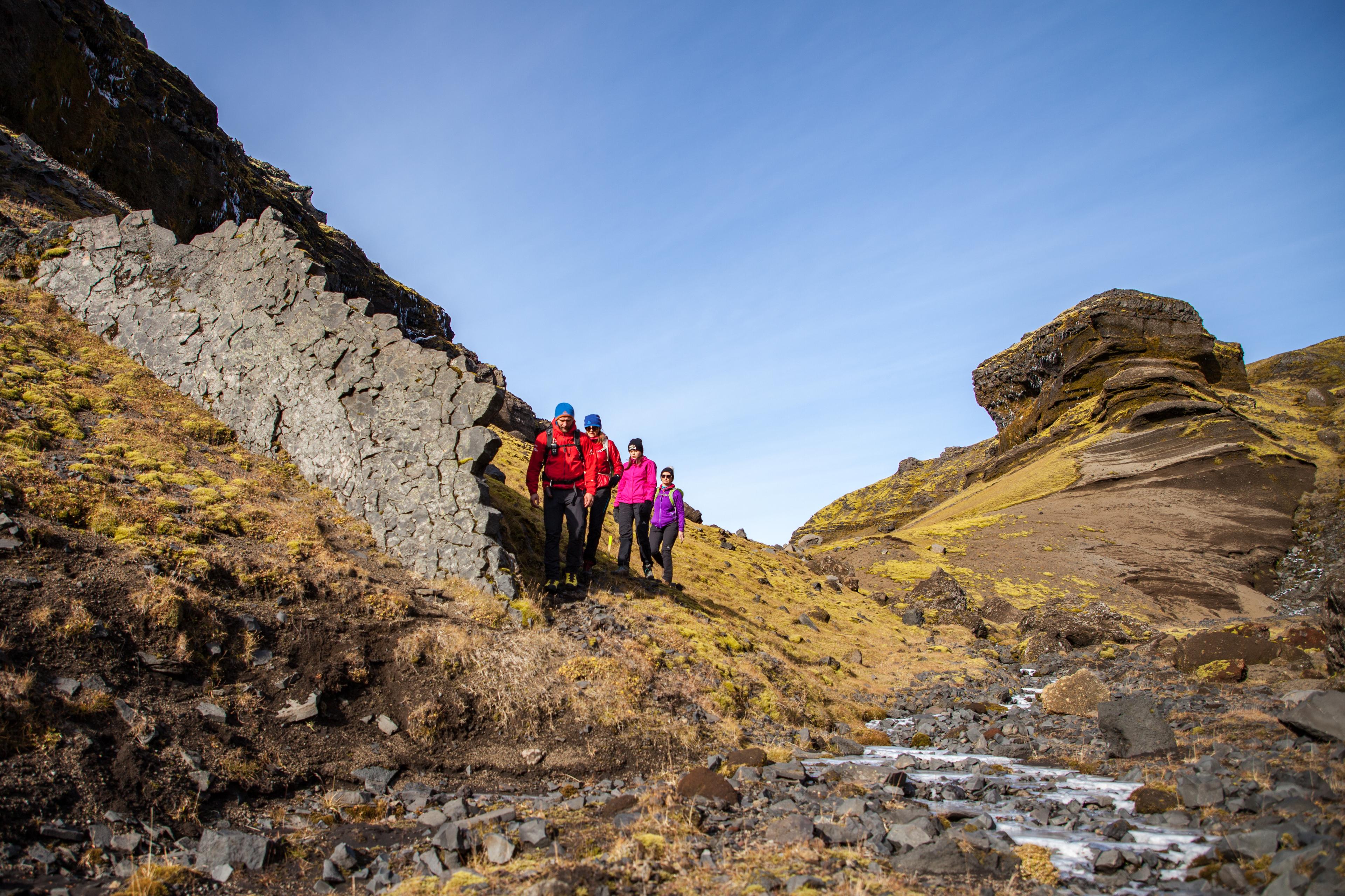 Hikers walking past spectacular rock wall formation