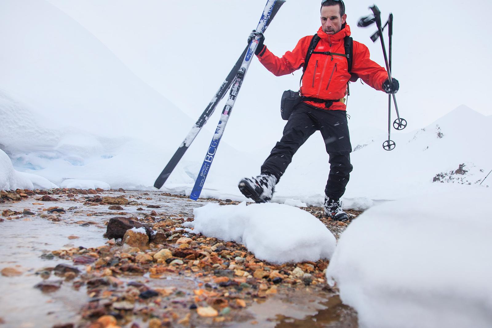 Man crossing small river with skiing gear in Landmannalaugar