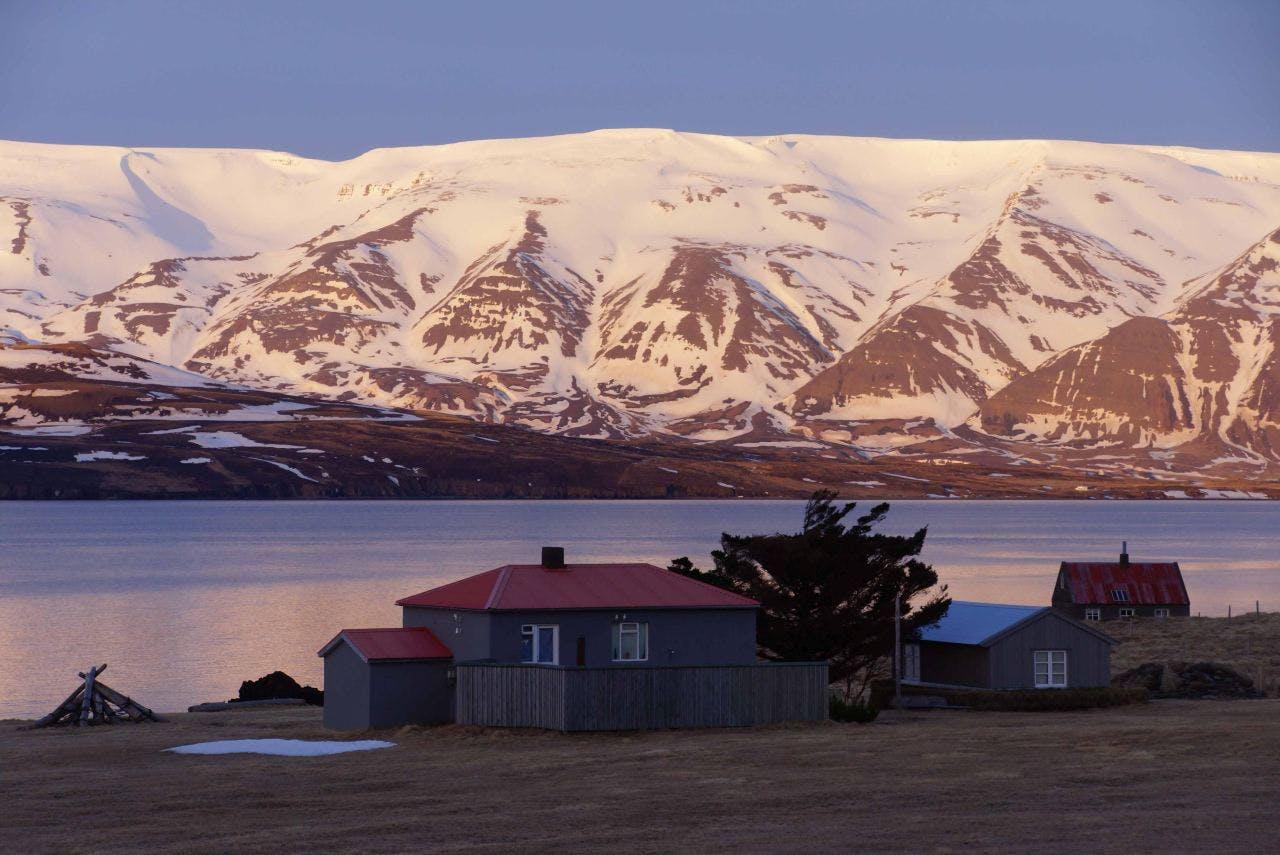 a cabin in front of a snowy mountain in Iceland