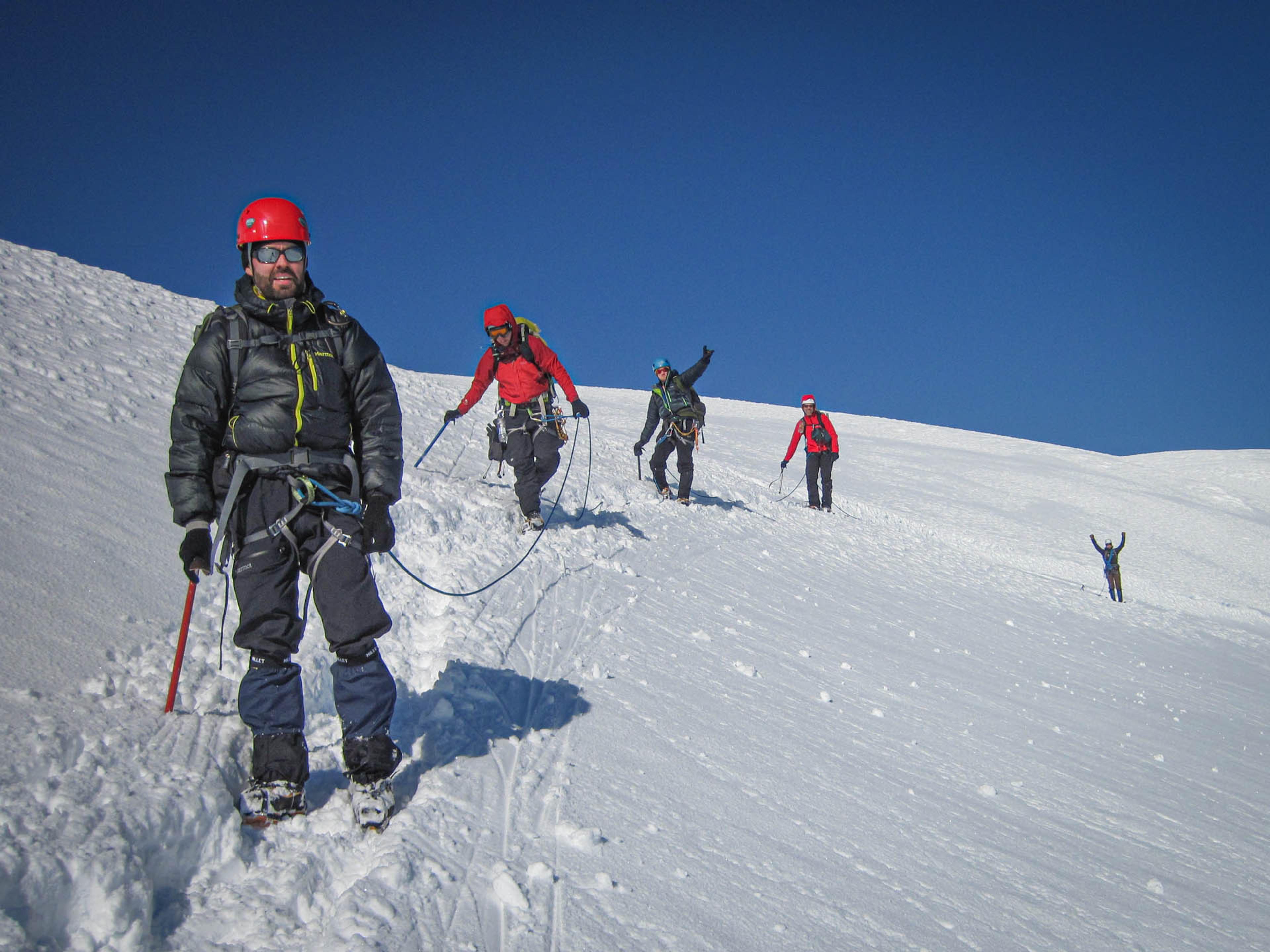 people hiking on a snowy mountain in line