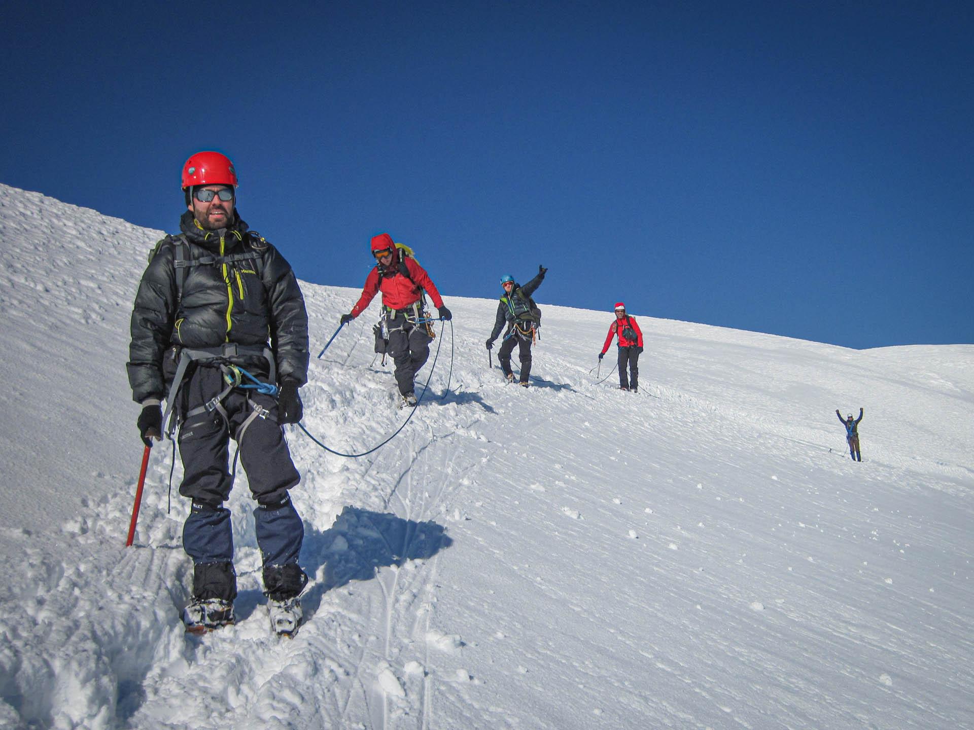 people hiking on a snowy mountain in line