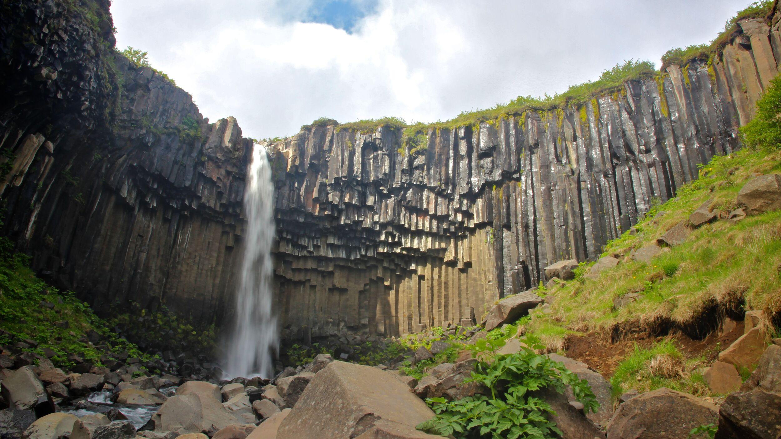 Close-up view of Svartifoss waterfall plunging over striking hexagonal basalt columns in Skaftafell, Iceland.