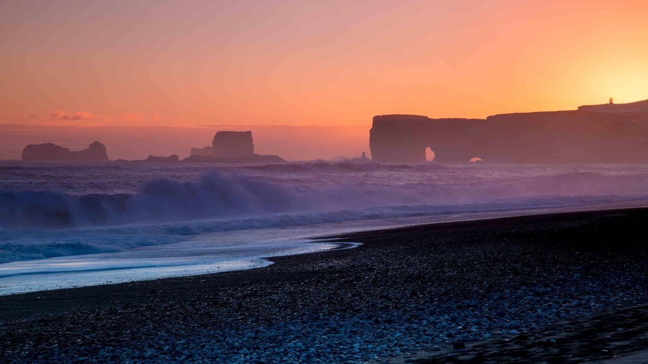 A beautiful sunset in Iceland at a beach with square mountains and black sand