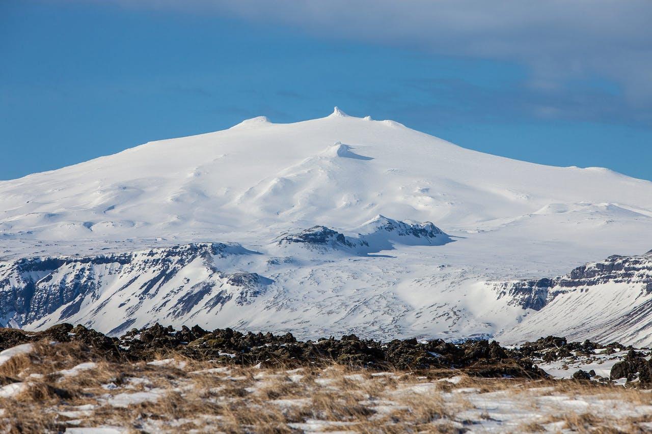 Snaefellsjoekull in Iceland: Snowcovered mountain with a crater on top with a blue sky in the background