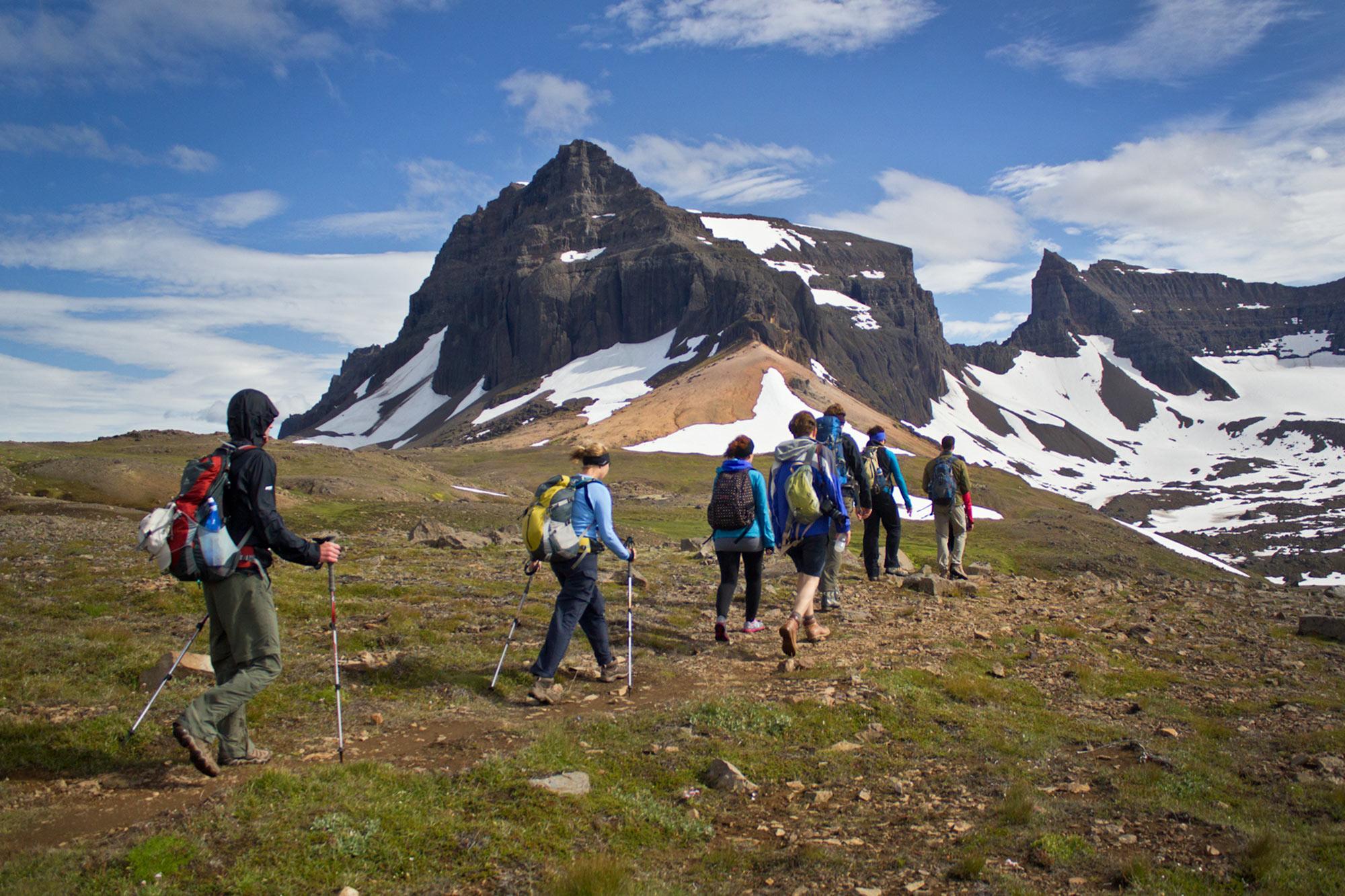 People on a Iceland hike tour with snowy and hilly mountains ahead