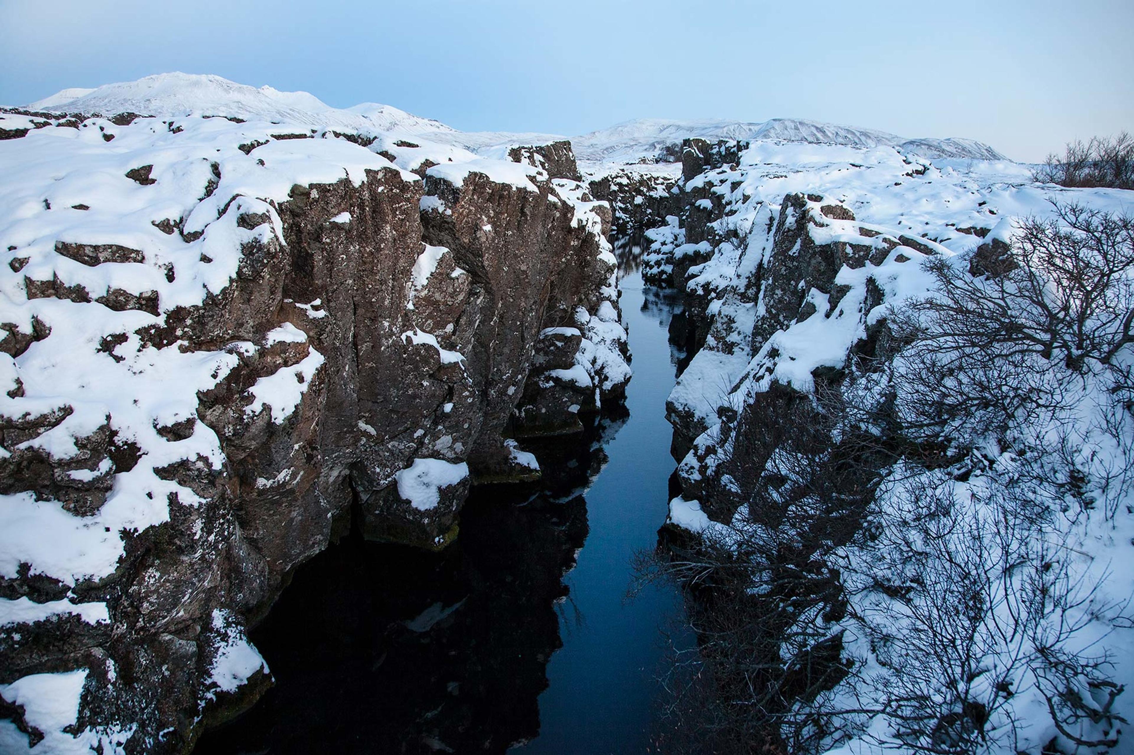 A narrow river between snow-covered rocks