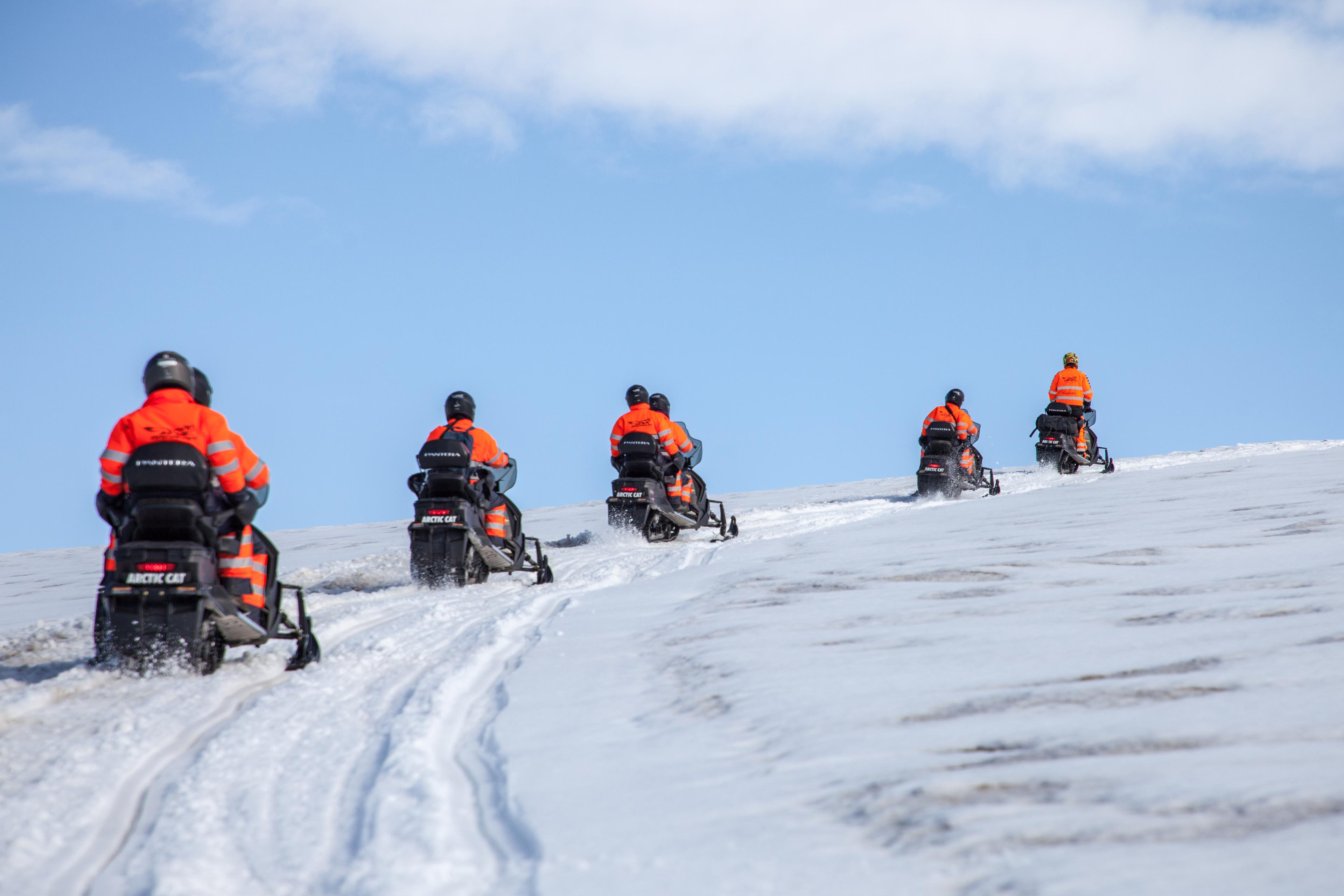 Group of snowmobile drivers nearing the highest point of the glacier tour that dayw