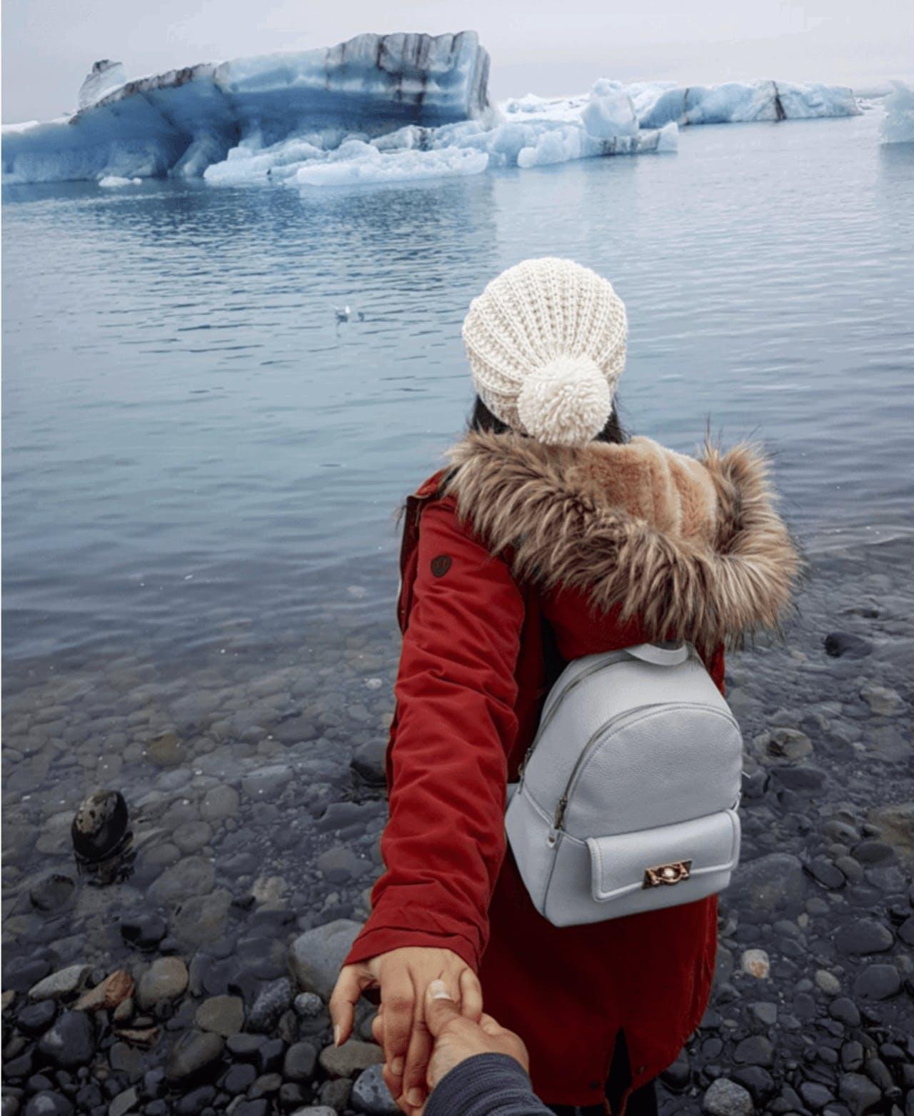A woman in red looking at ökulsárlón Glacier Lagoon