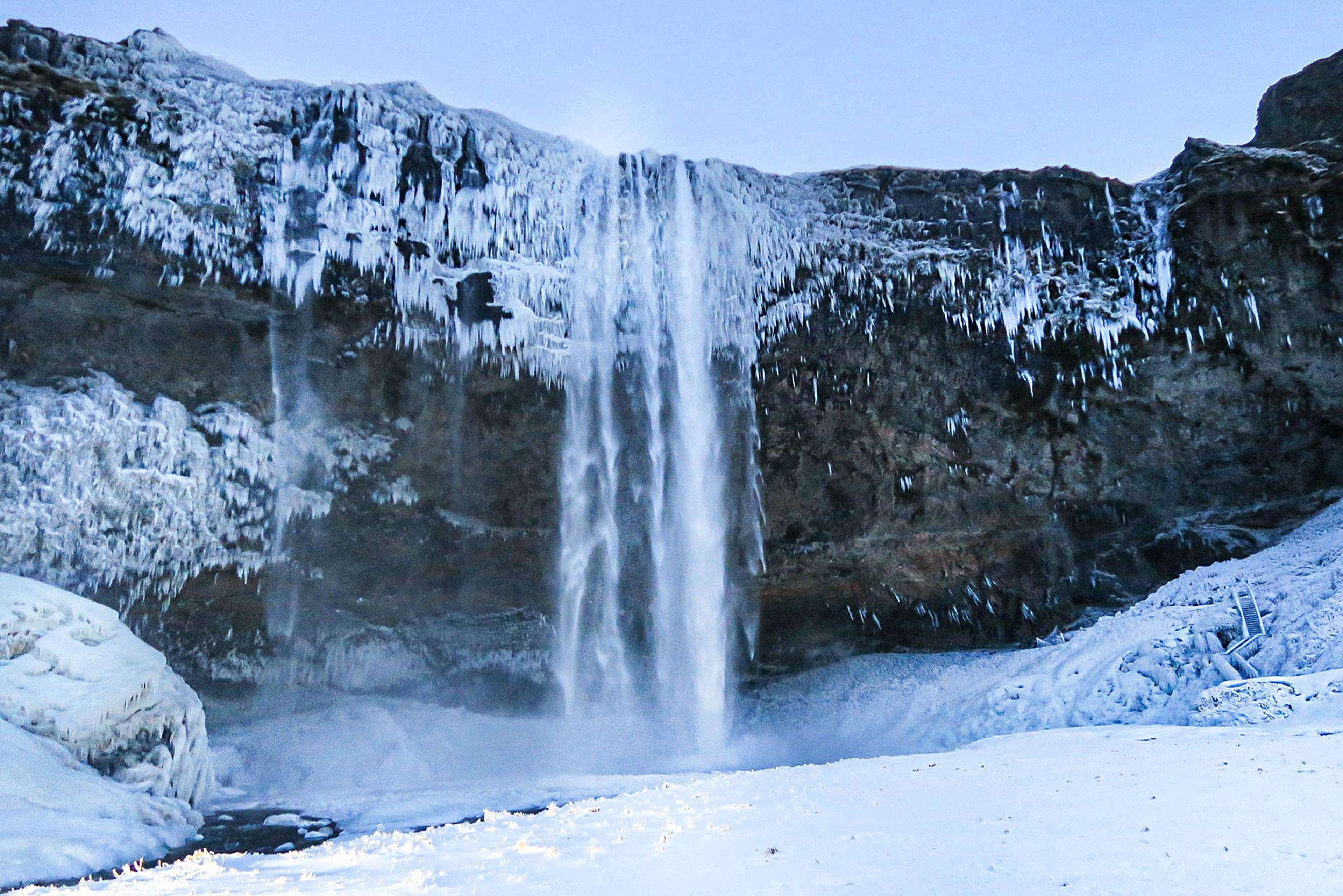 Seljalandsfoss coverd in snow on a blue day
