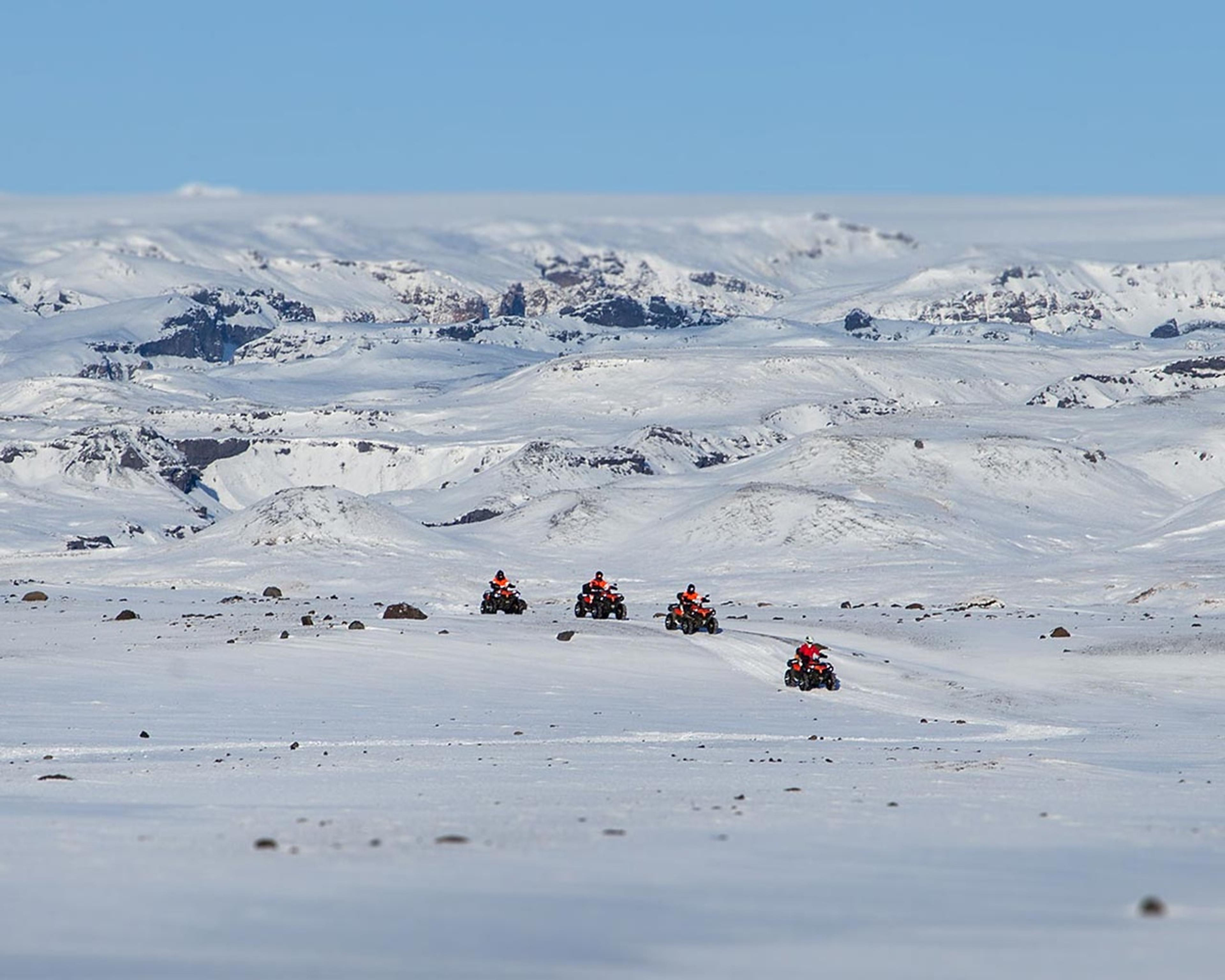 ATV quad bikes travelling through the snow covered area of Sólheimasandur on the South coast of Iceland