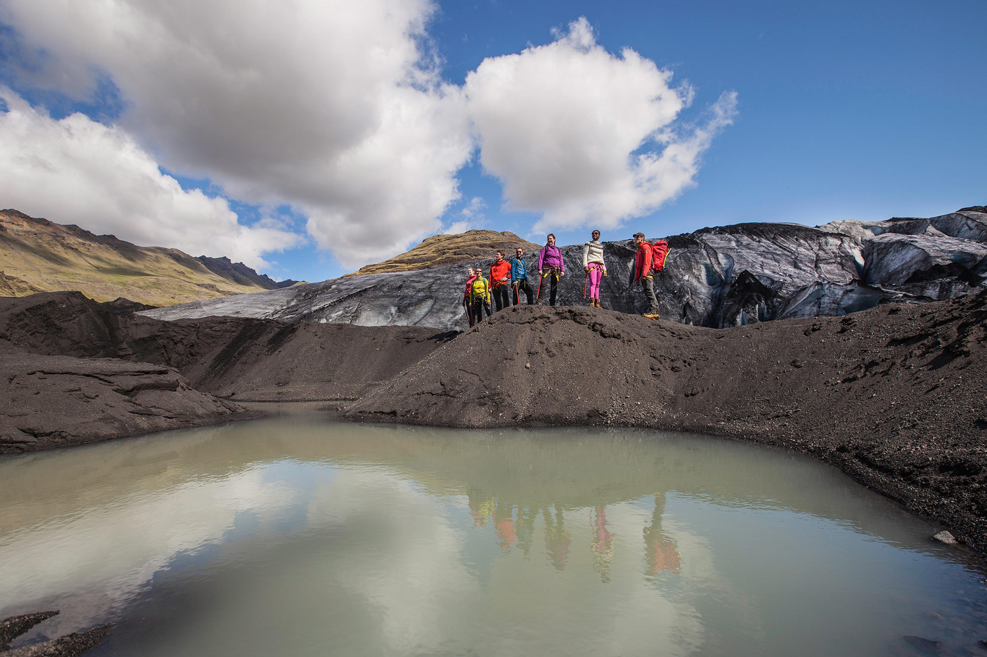 People looking down into a lagoon next to Sólheimajökull in Iceland