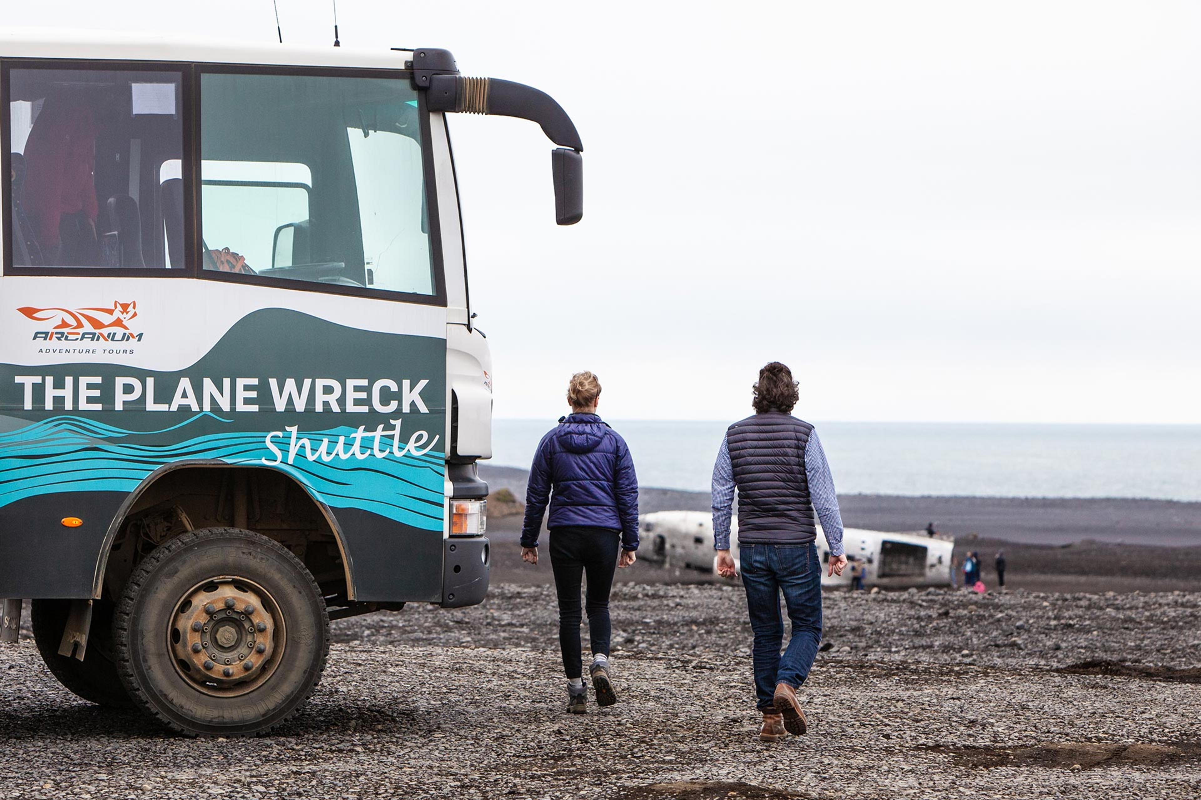 A couple getting closer to the wreck on Sólheimasandur