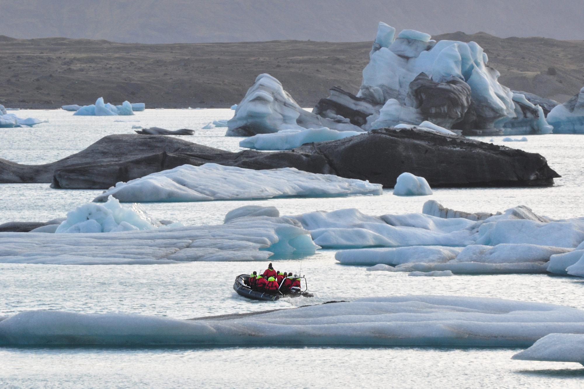 A small boat going in between icebergs on Jökulsárlón glacier lagoon