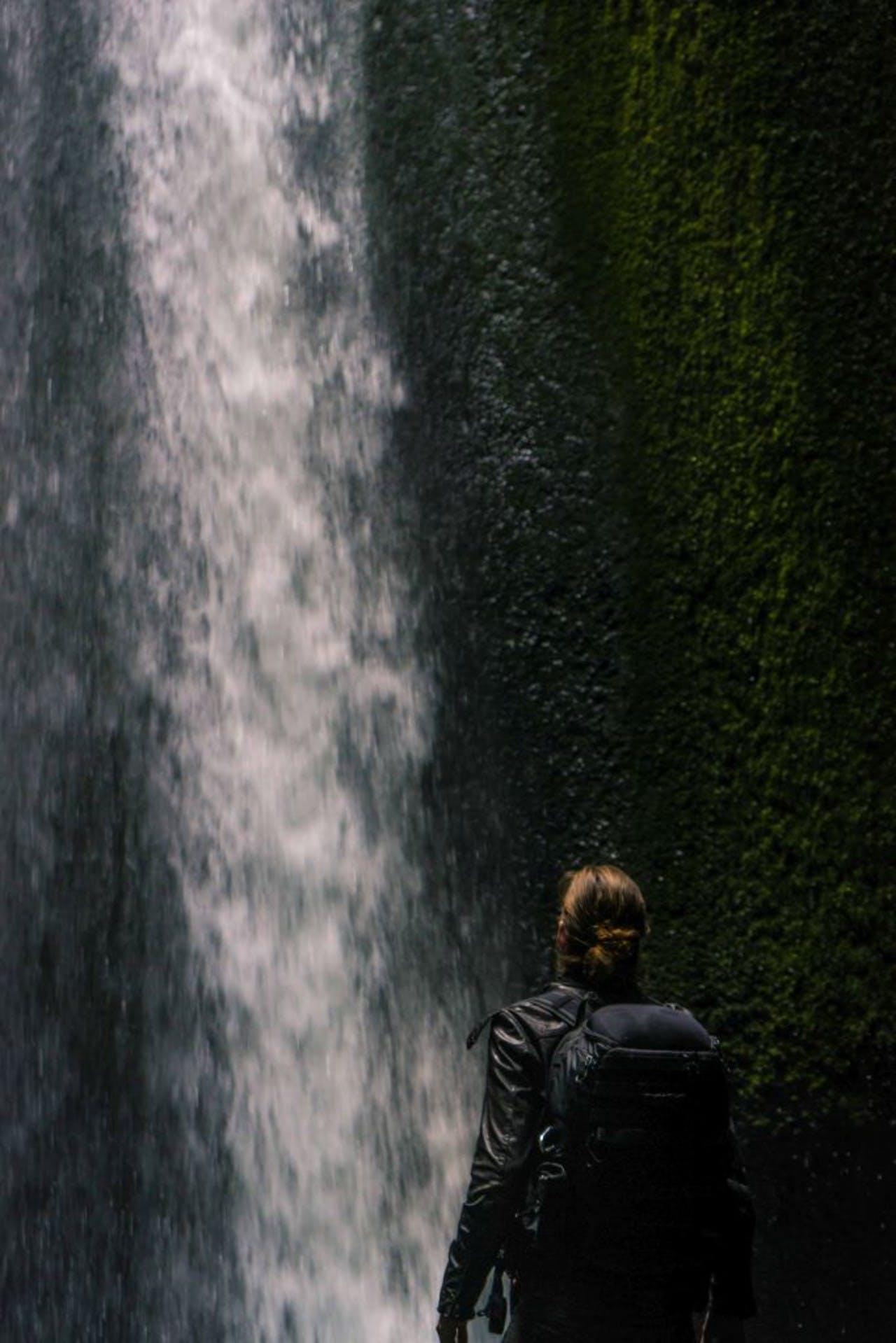 person looking at Gljúfrabúi Waterfall