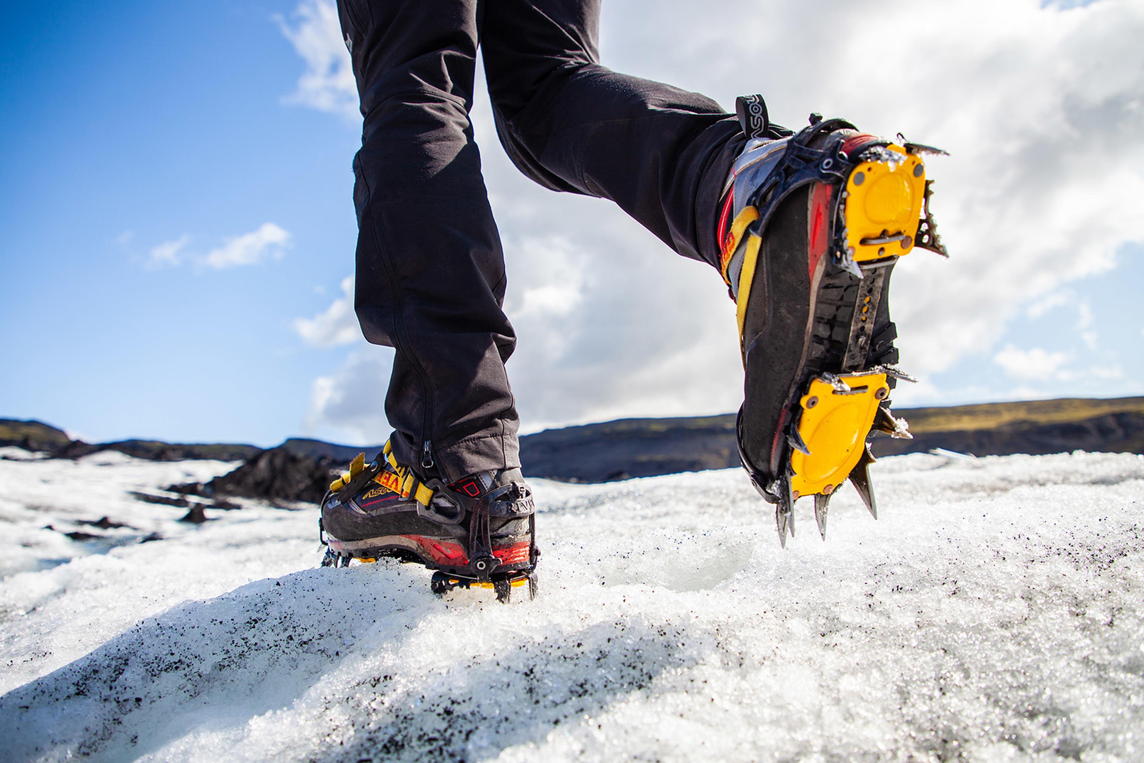 Crampons on feet walking on a glacier