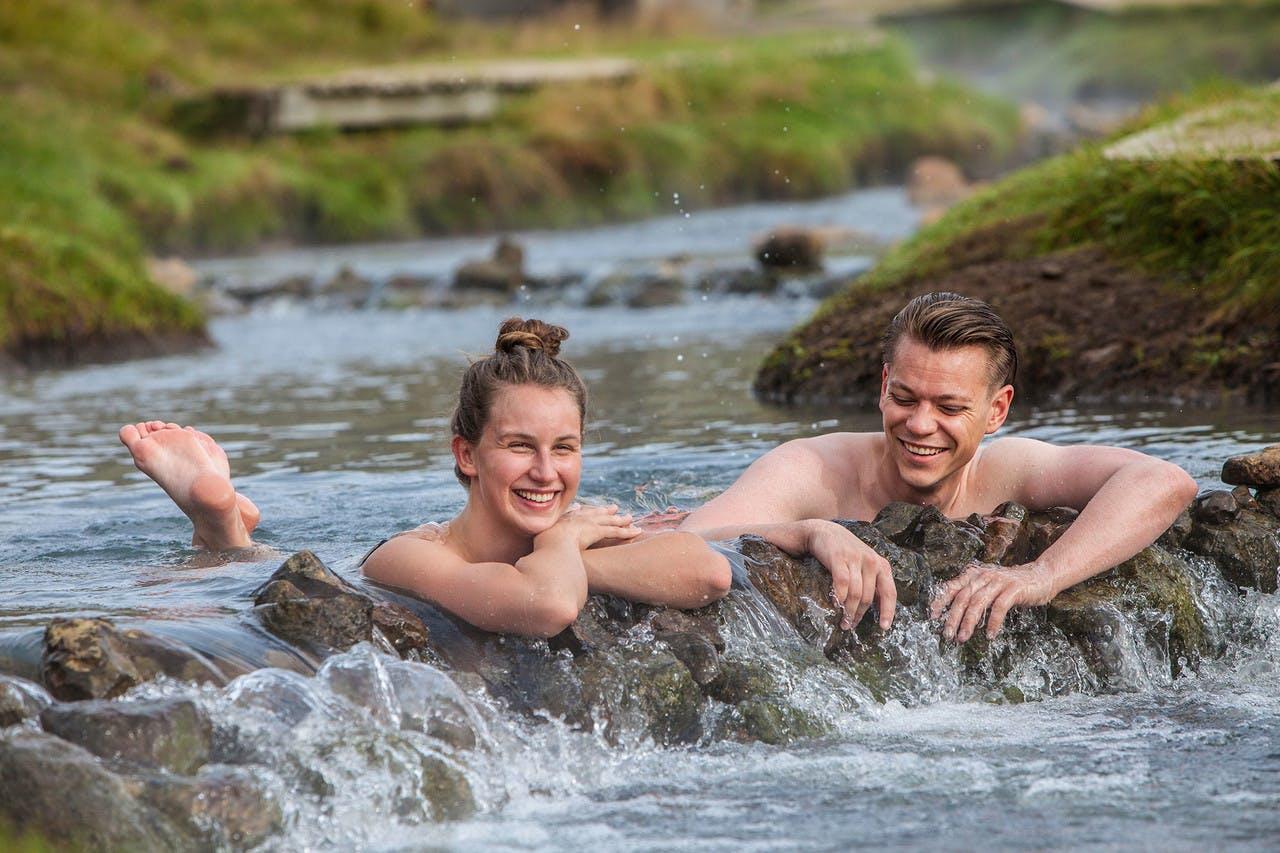 People enjoying the hot water in Reykjadalur hot spring thermal river in Iceland