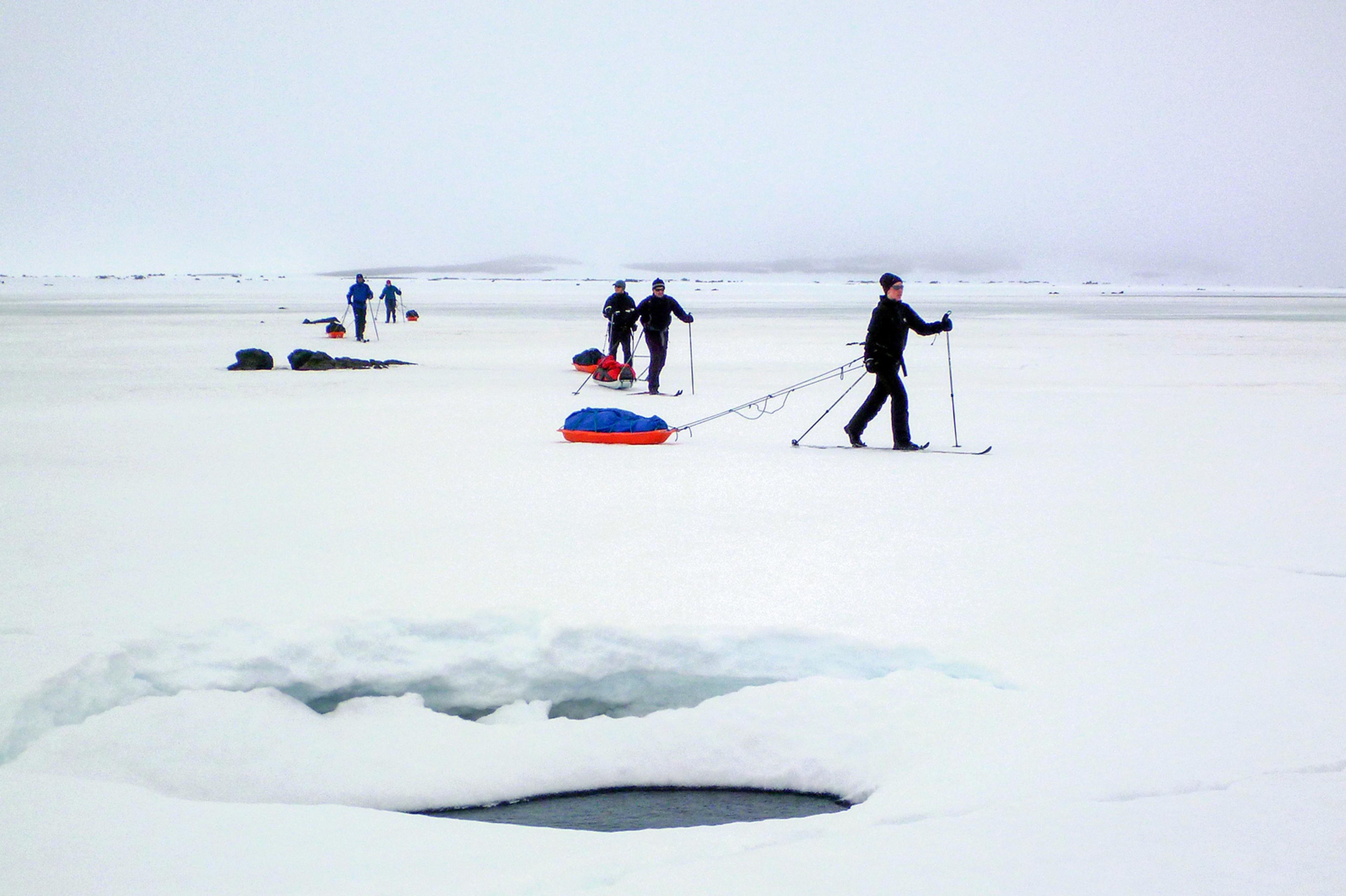 Skiers going past a pond in the highlands