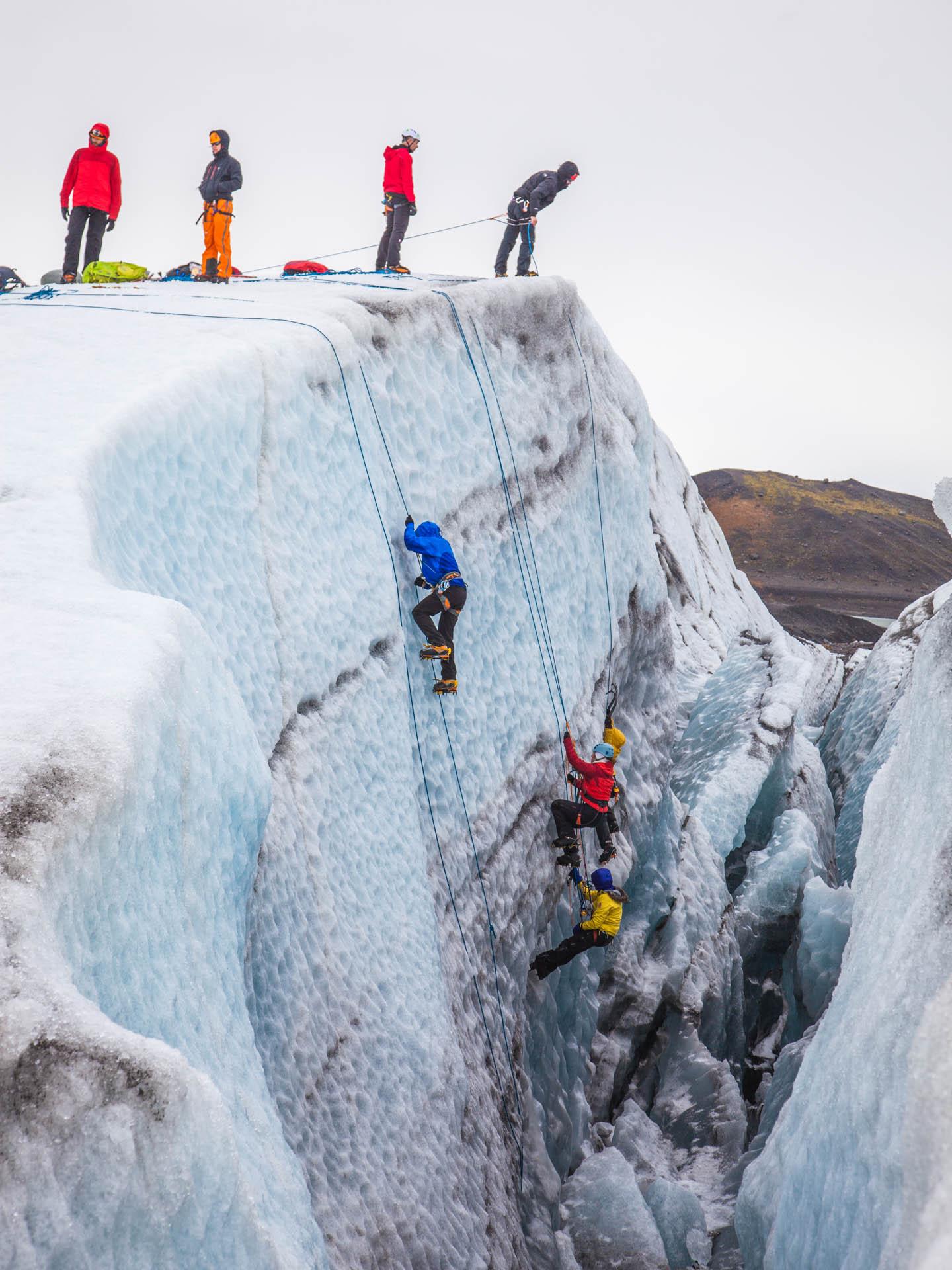 A group of people Ice climbing up a glacier