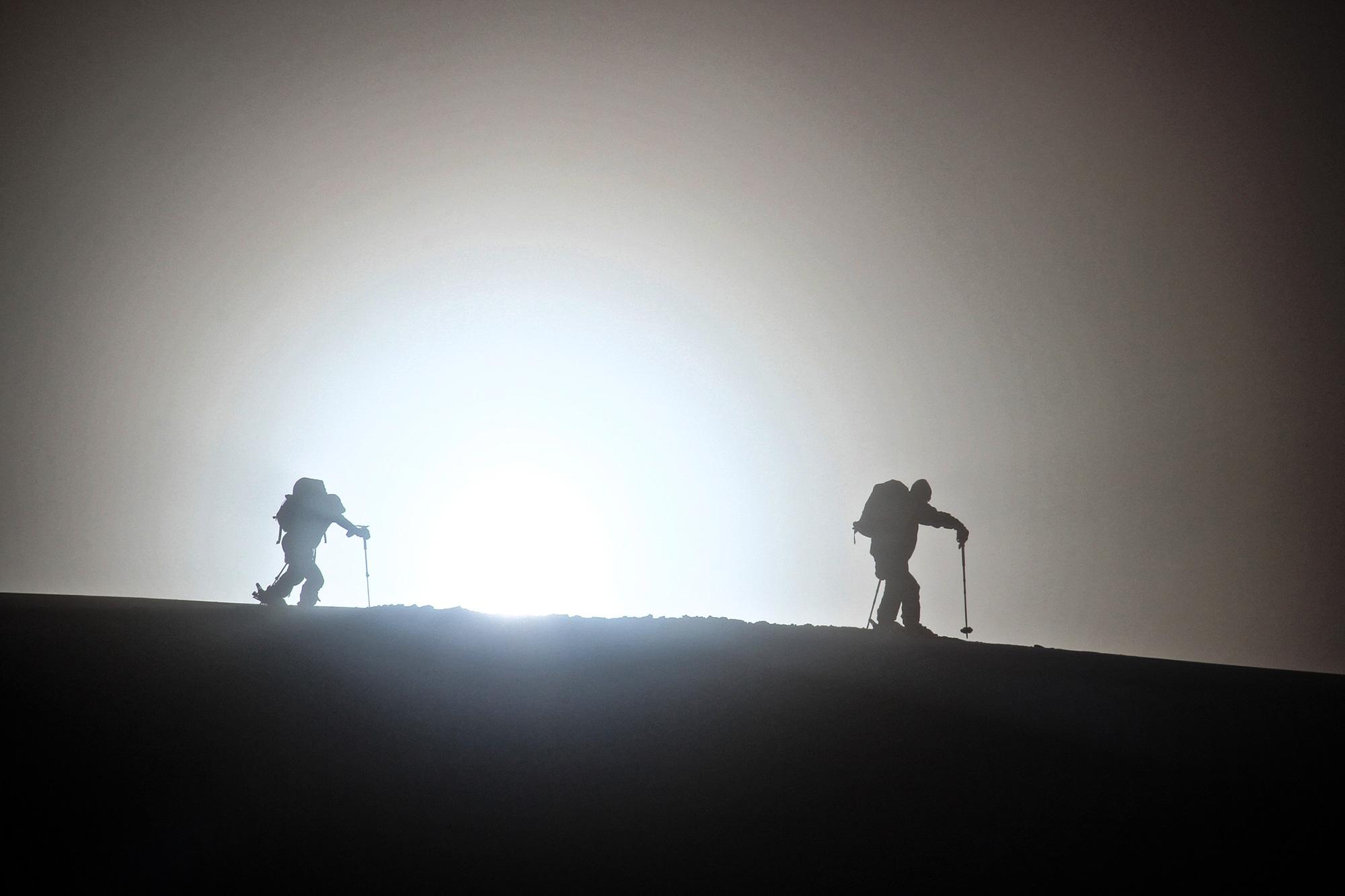 Two explorers ski touring in the North of Iceland while the sun is setting