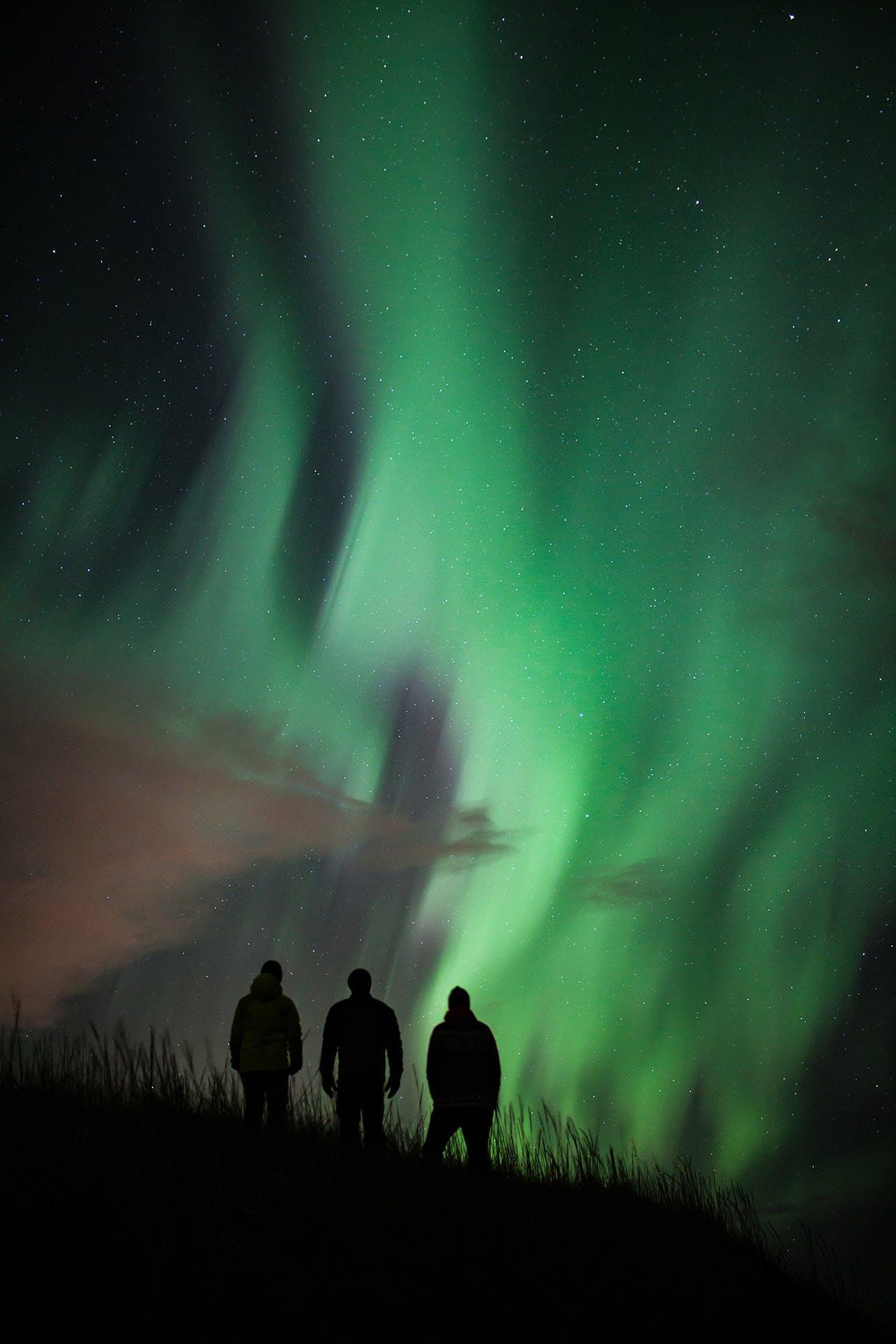 Three people viewing the northern lights