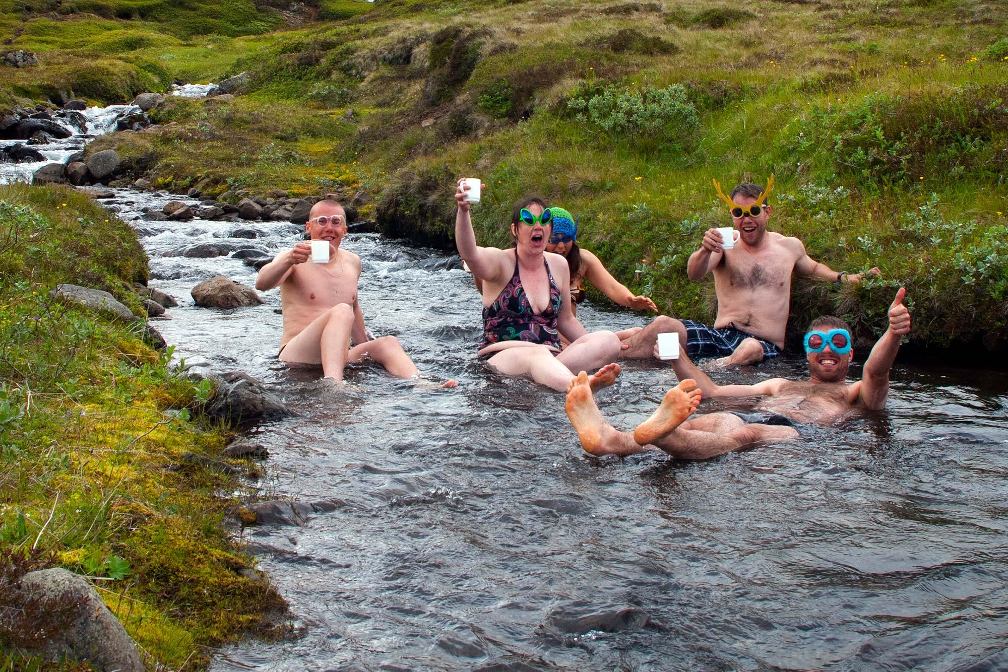 Happy people taking a bath in a small river in the eastfjords, Víkingaslóðir.