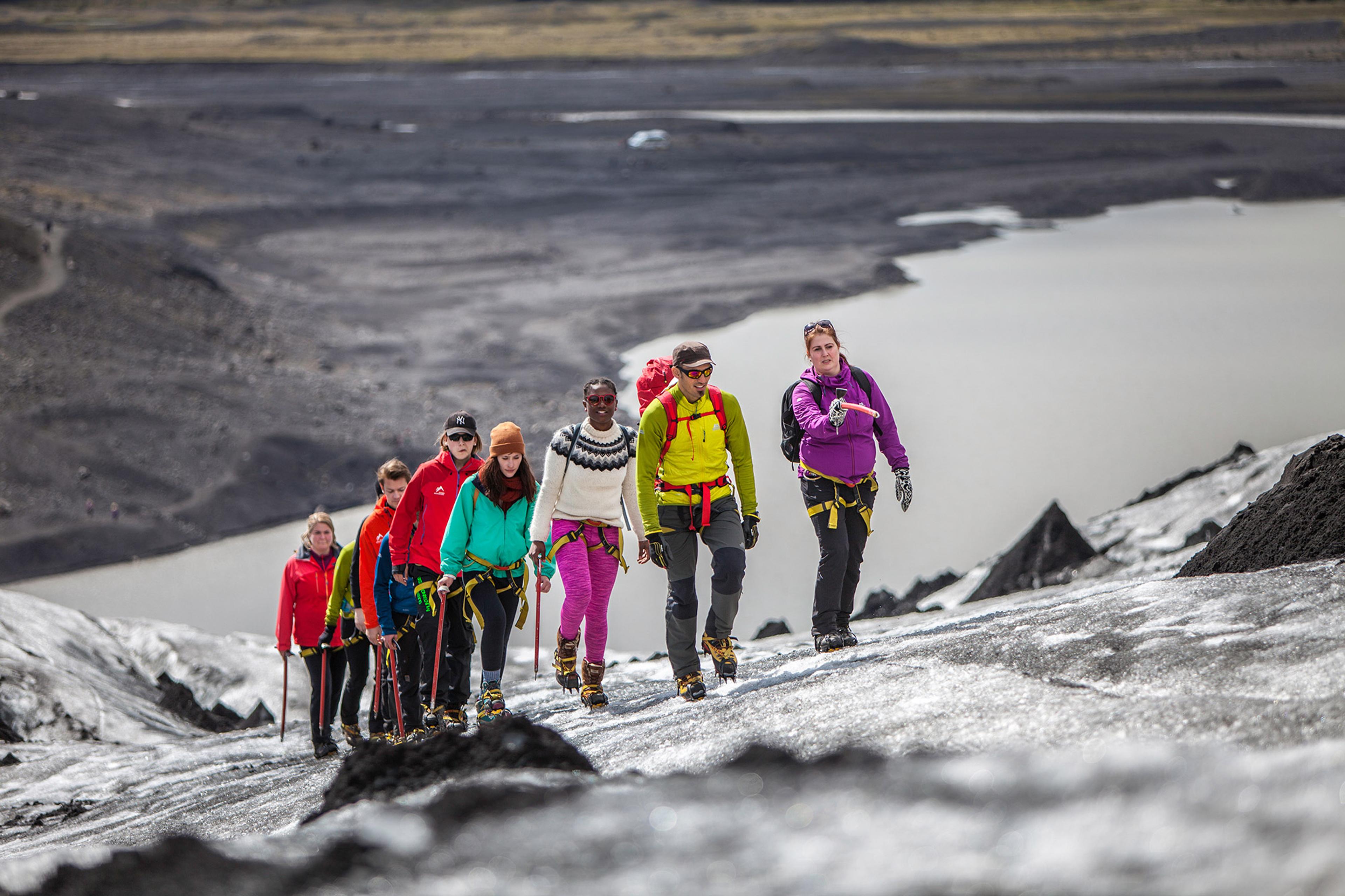 People glacier walking on Sólheimajökull with big river in background