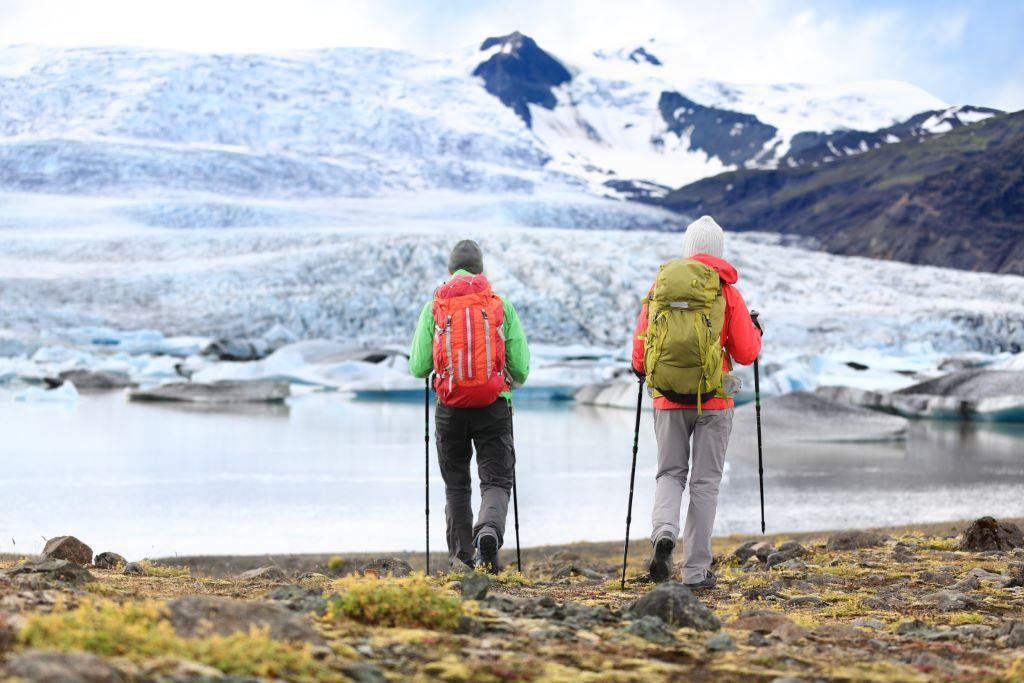 Hikers looking at a glacier lagoon with the glacier tongue in the background