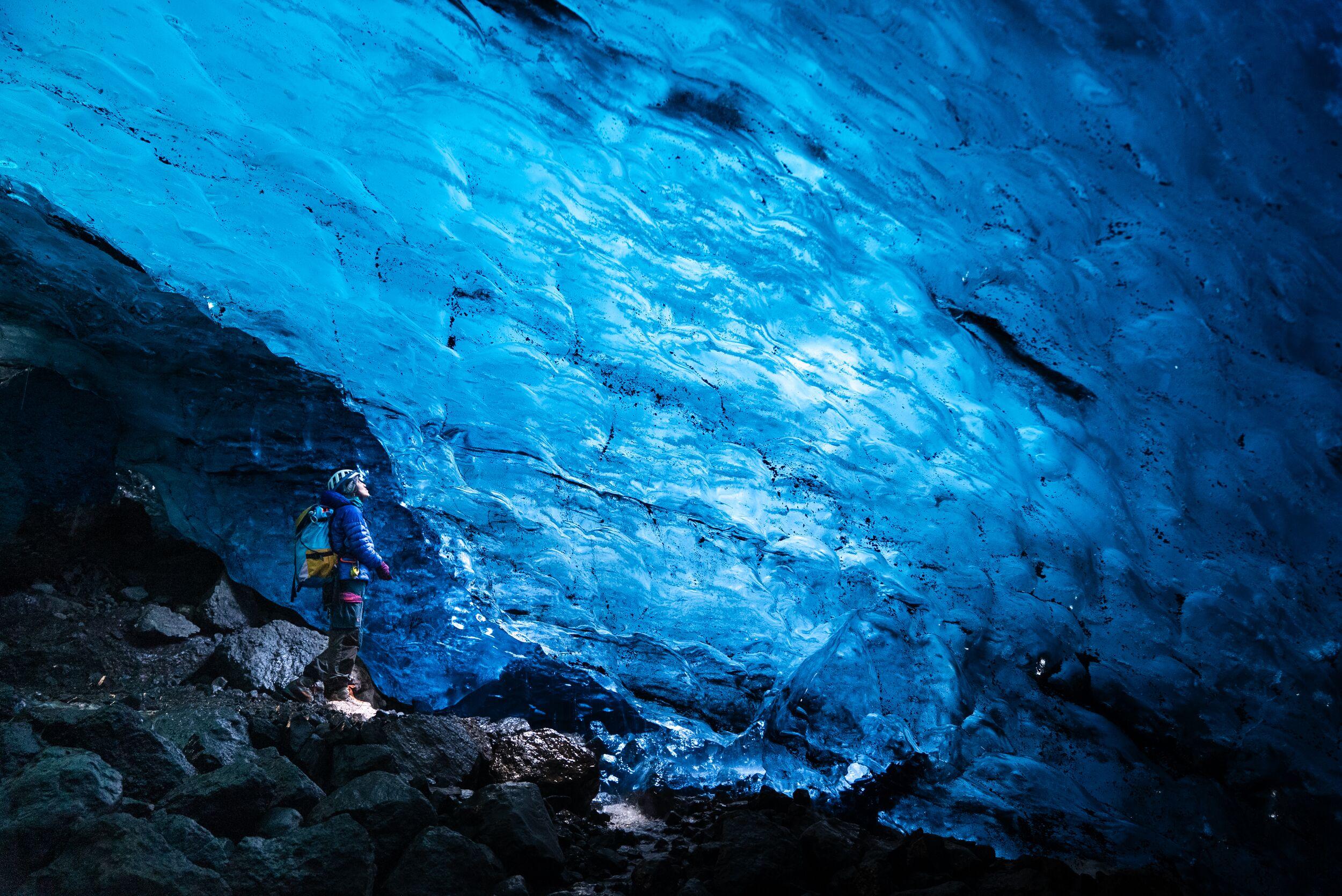 Person standing in a blue ice cave