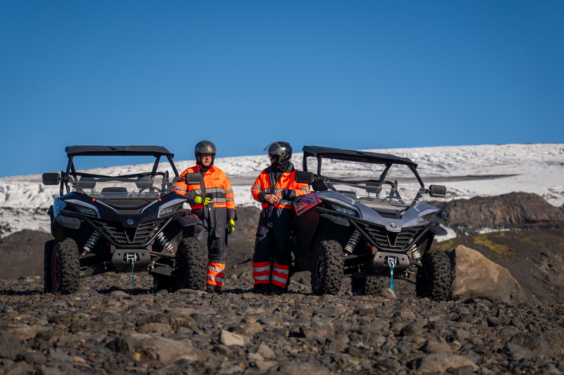 two man standing by two buggy by a glacier